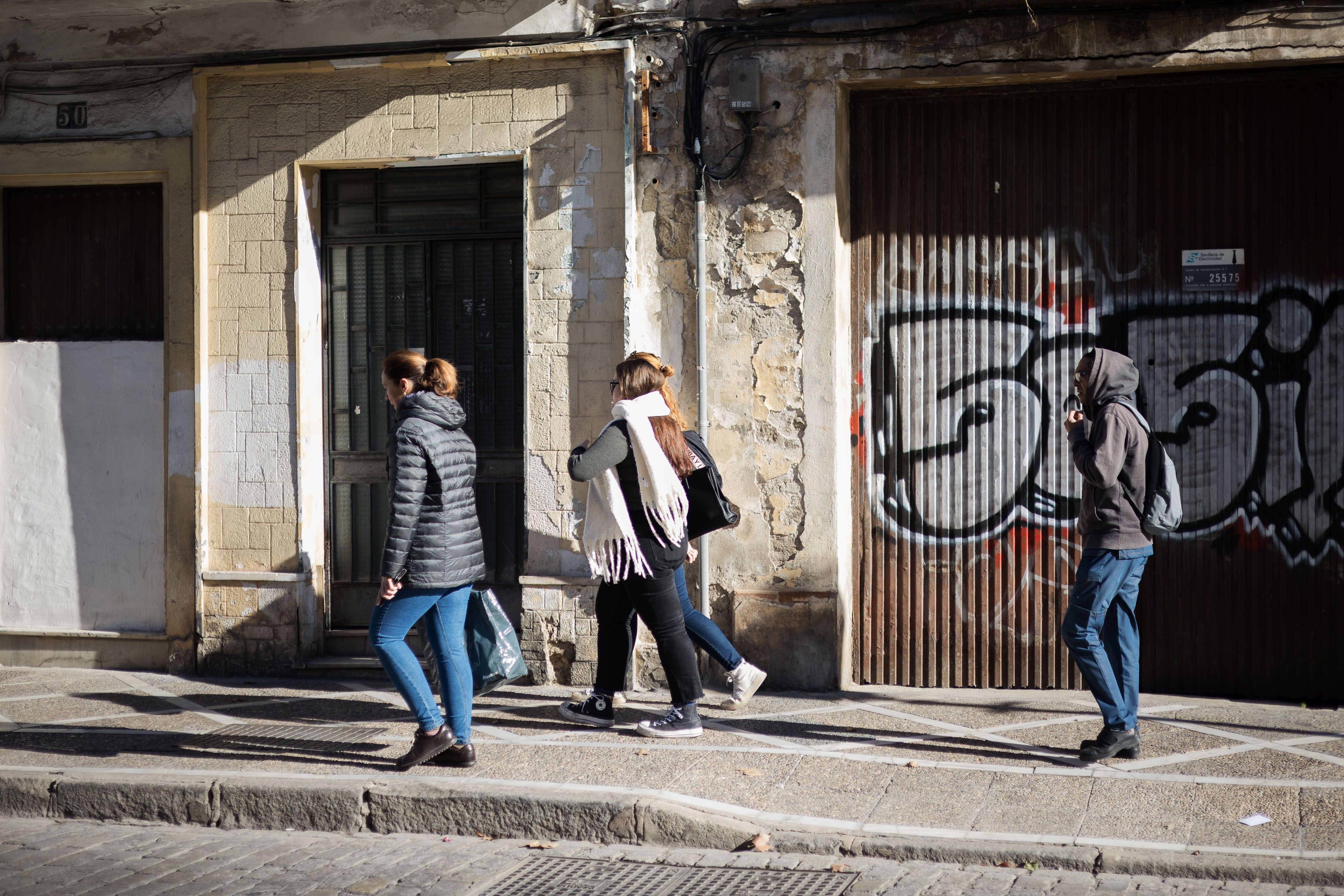 Personas paseando en invierno en Andalucía, todavía con los abrigos en las primeras horas del día.