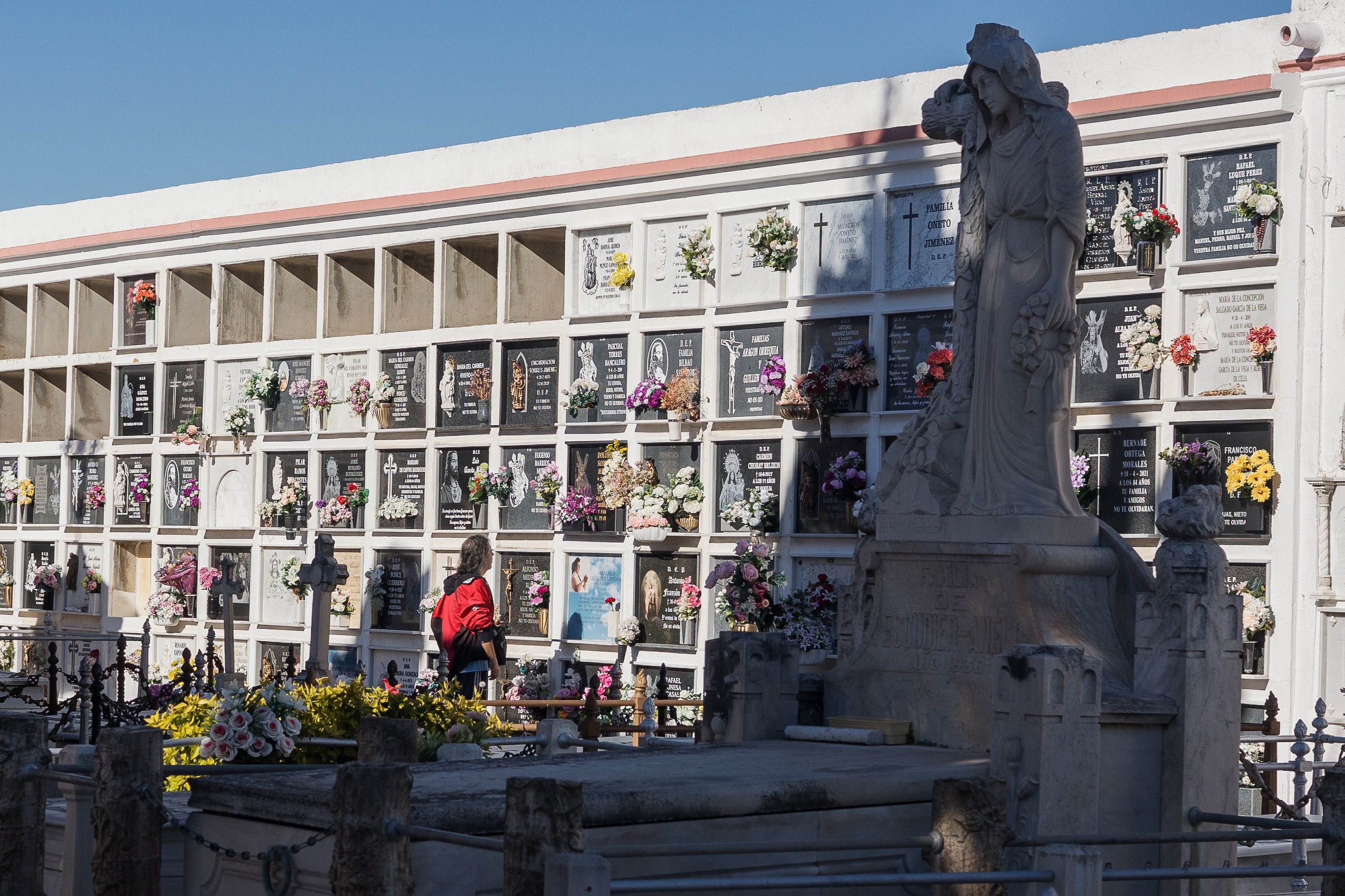 Una persona, frente a nichos en el cementerio de San Fernando.