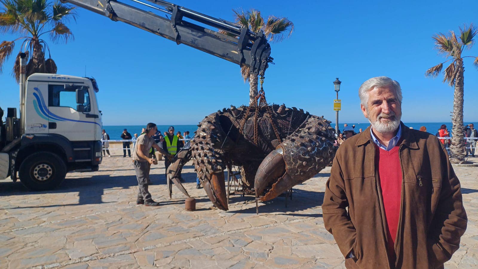 El alcalde de Chipiona, Luis Mario Aparcero, con la obra del cangrejo gigante de Zarazaga detrás.