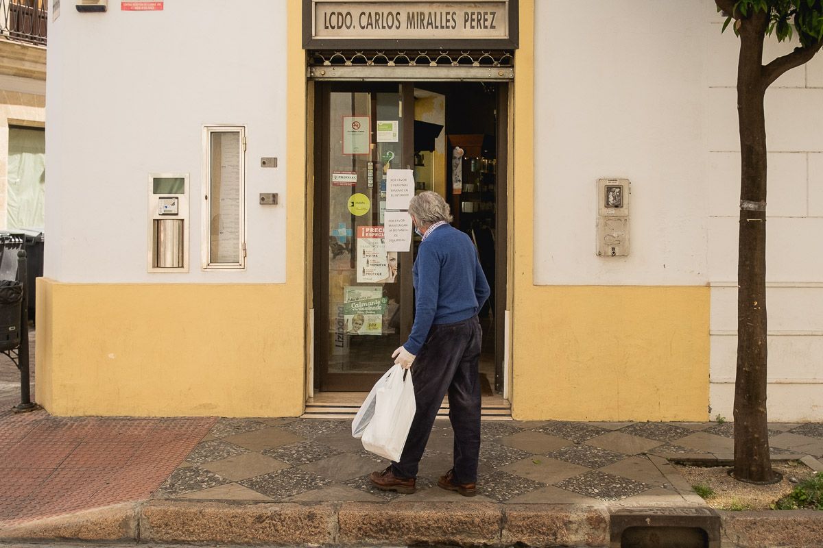 Una persona mayor, frente a una farmacia durante la pandemia.