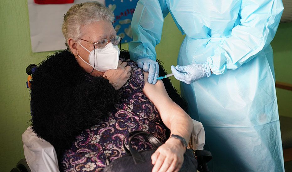 Una mujer mayor, vacunándose de la gripe.
