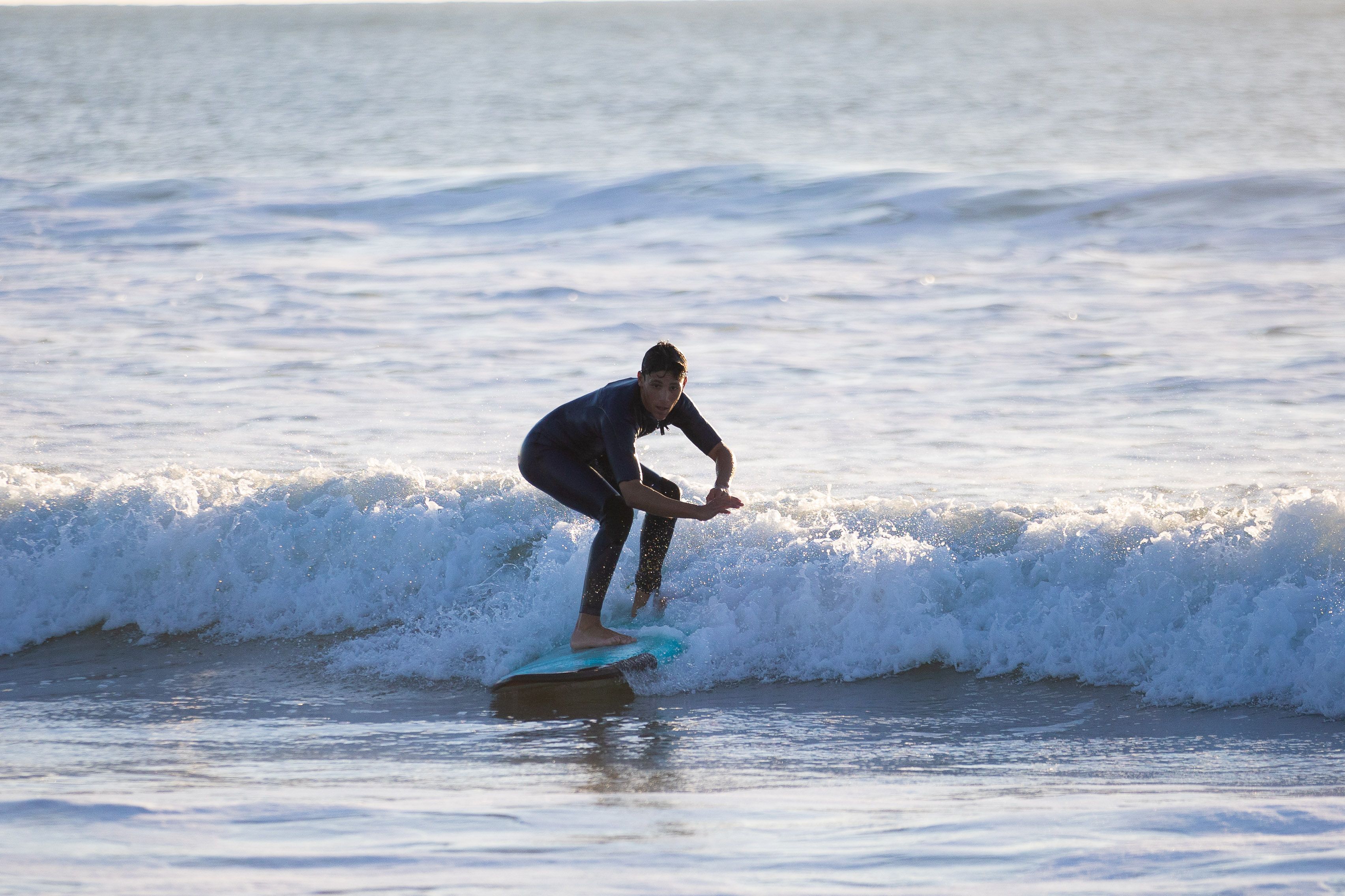 Uno de los voluntarios coge una ola.