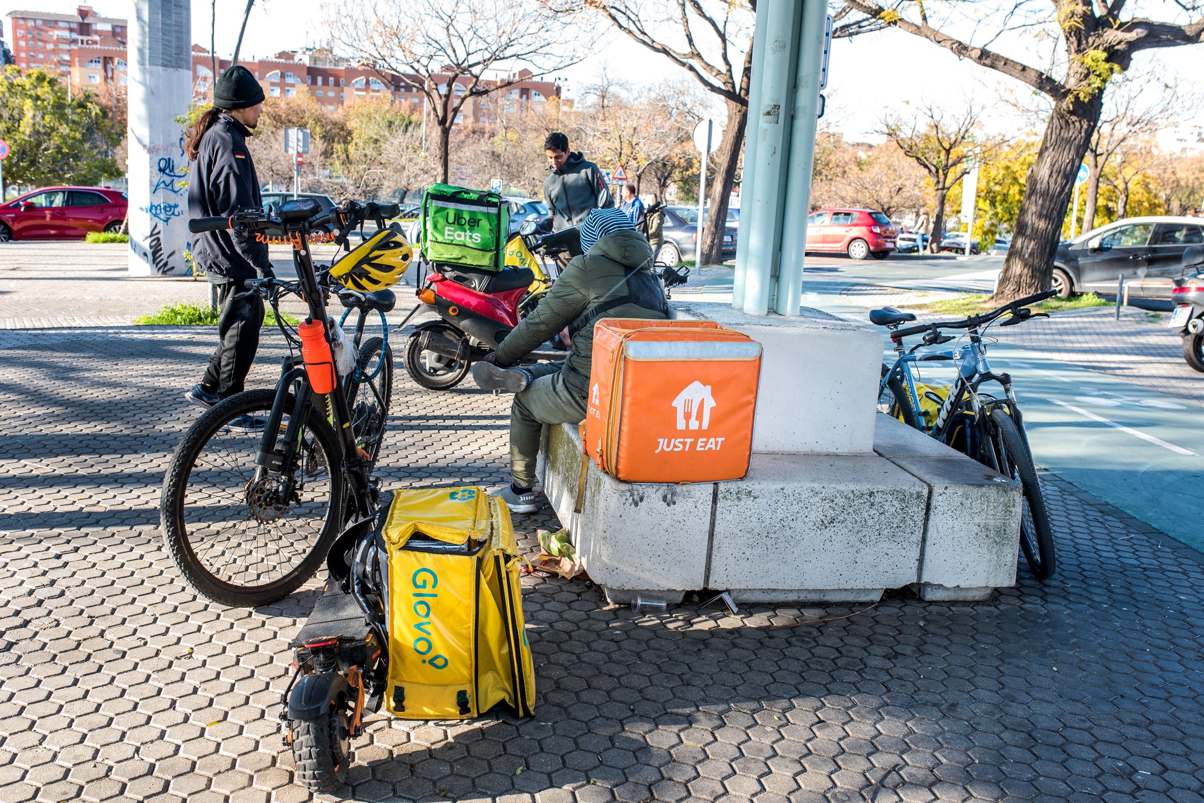 Repartidores de Glovo, descansando entre repartos.