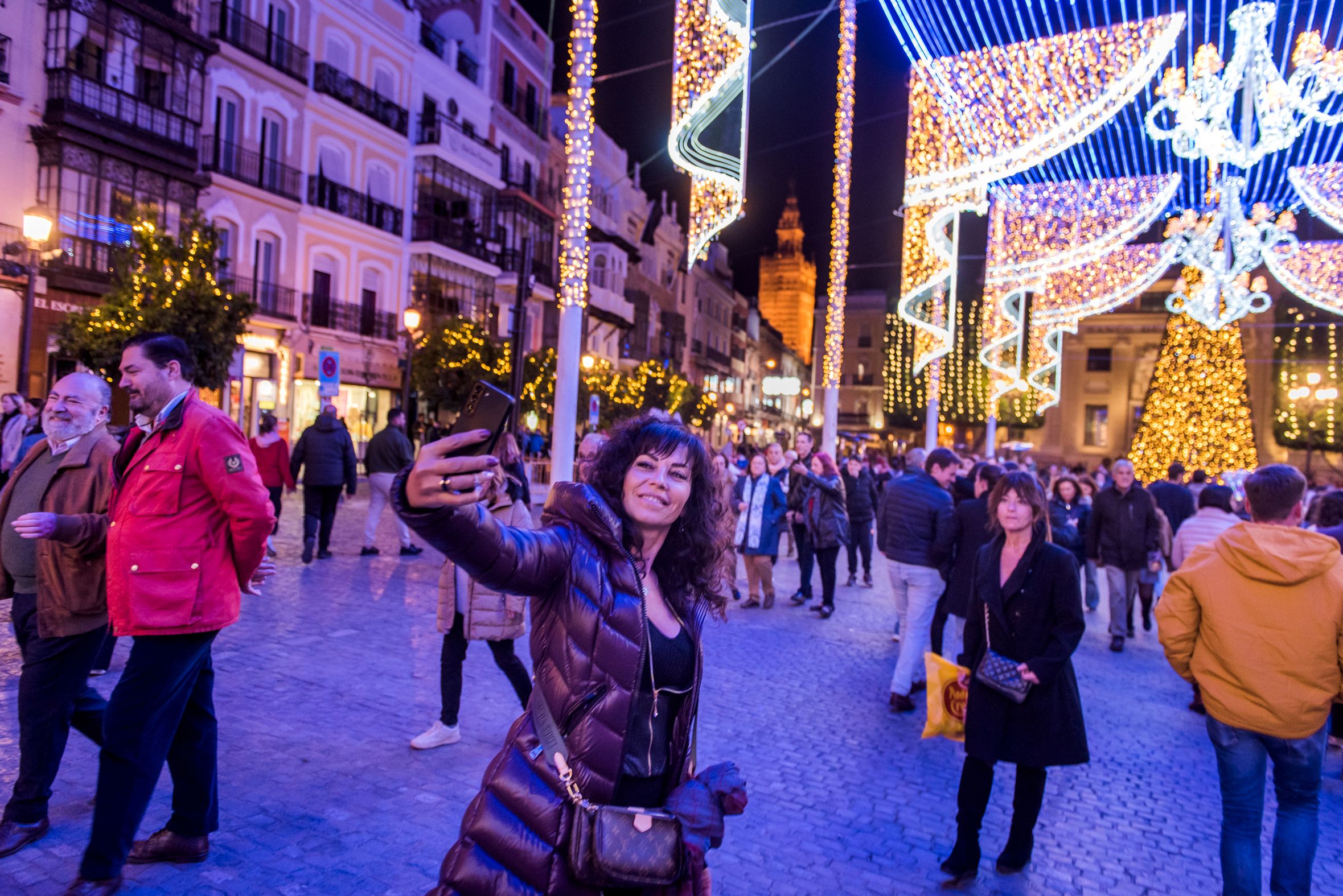 Una personas se hace un 'selfie' con el alumbrado navideño de Sevilla.