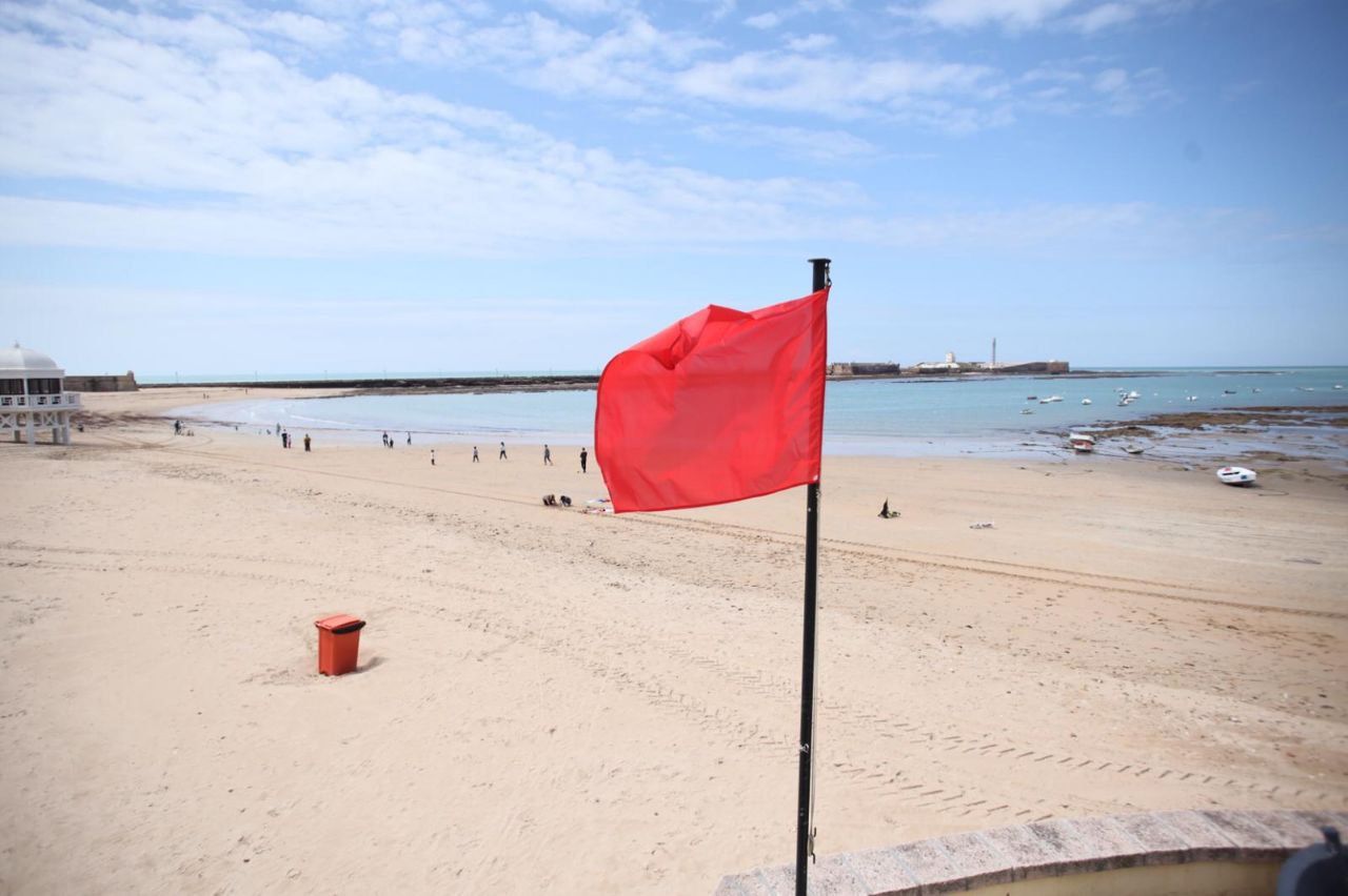 Una playa de Cádiz, con bandera roja durante el confinamiento. FOTO: JUAN CARLOS TORO