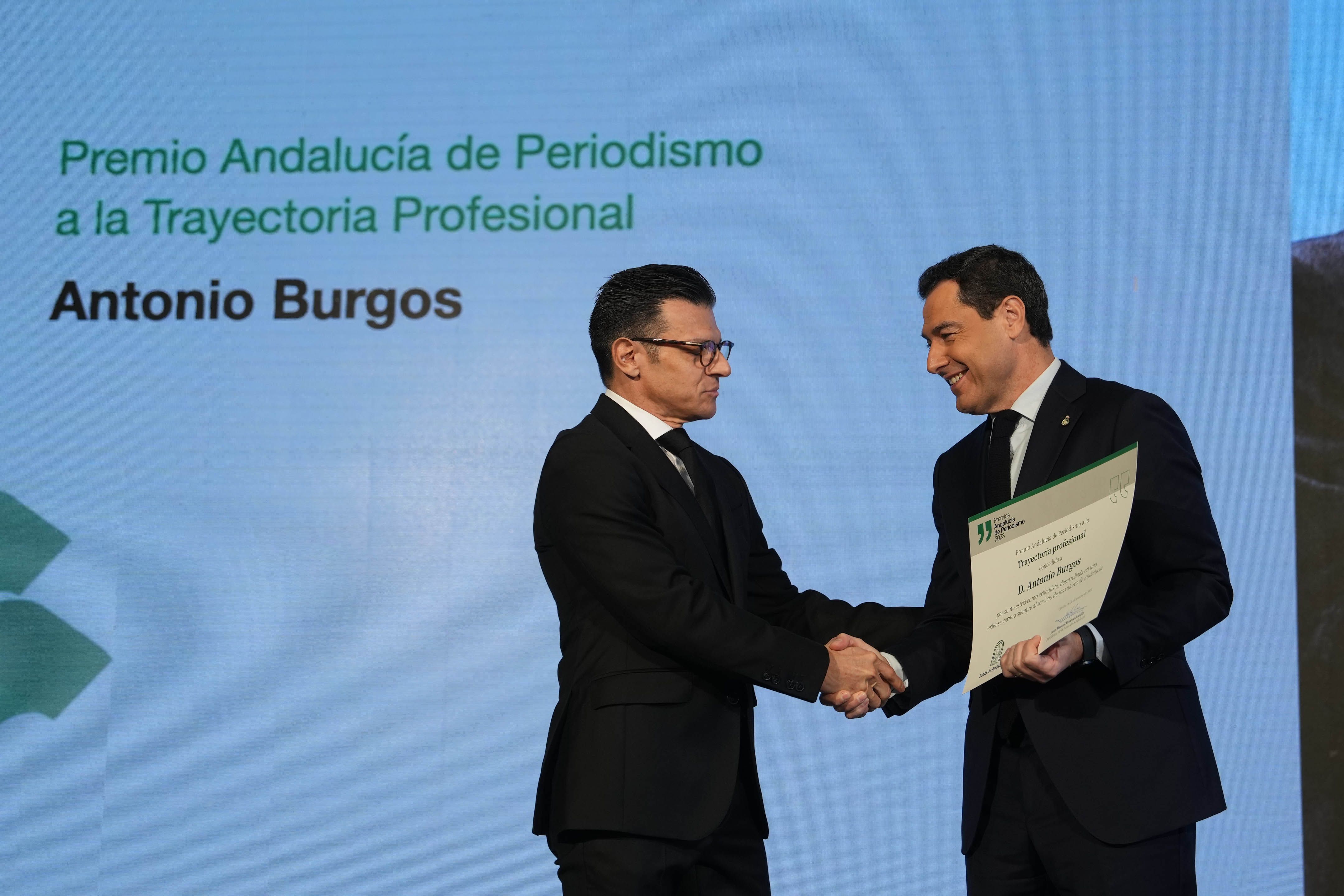 Juanma Moreno entregando el reconocimiento al hijo de Antonio Burgos.
