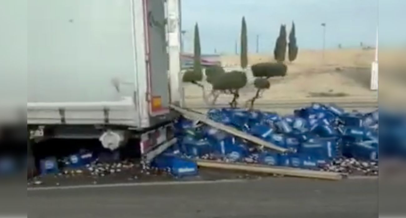 El camión, con las cervezas en el asfalto.
