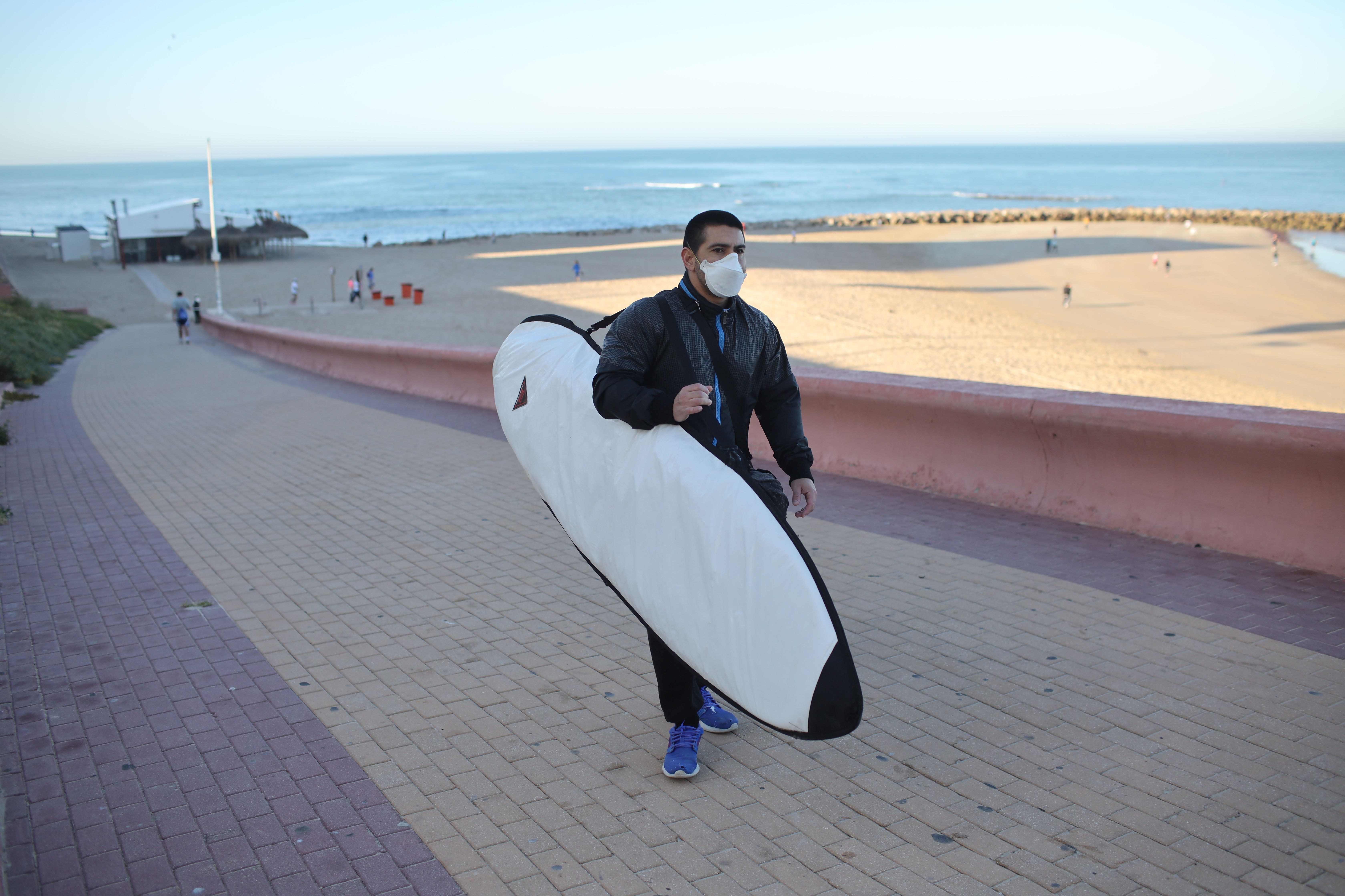 Un surfista abandona la playa, en Cádiz, el fin de semana pasado. FOTO: JUAN CARLOS TORO