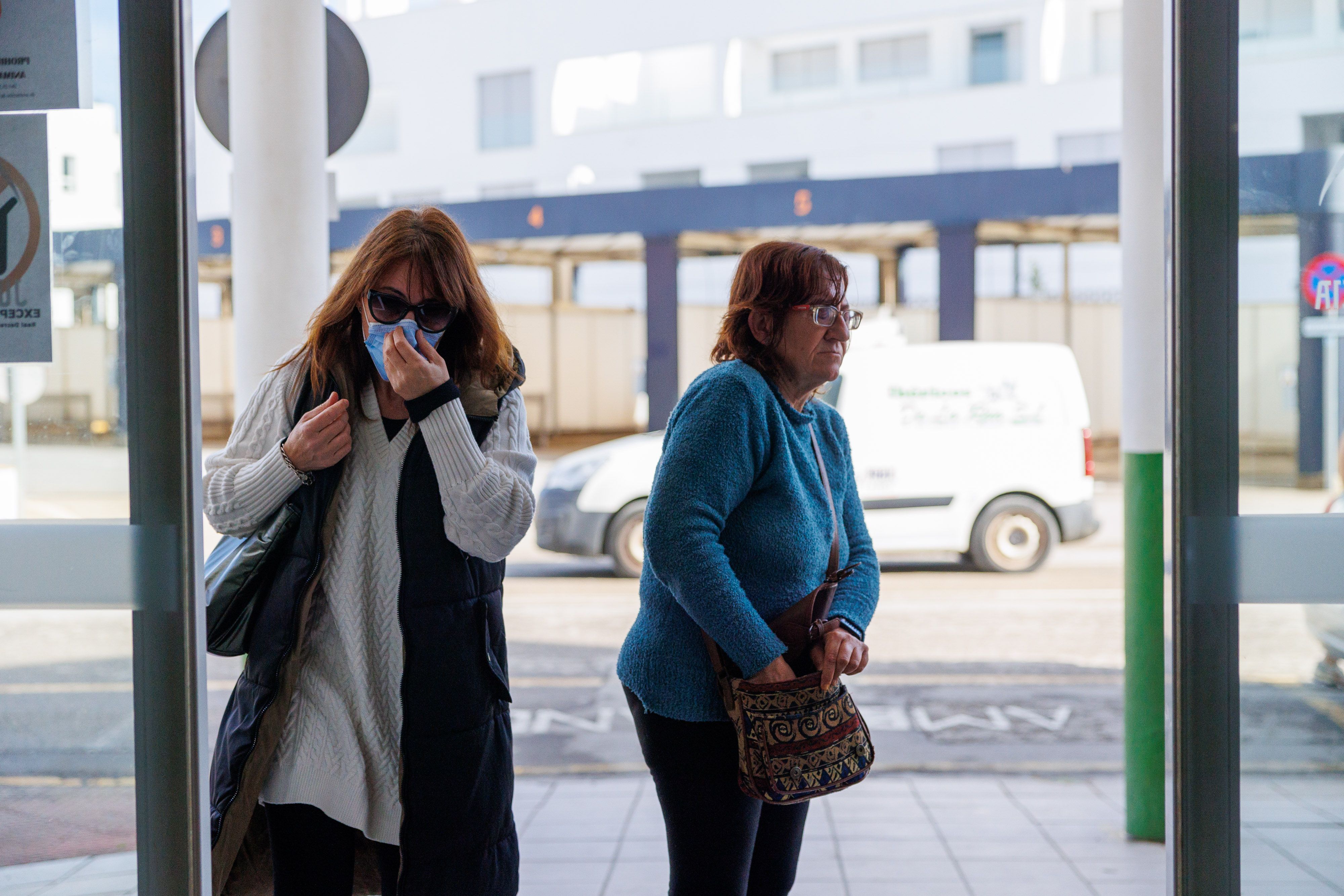 Una usuaria busca la mascarilla en el bolso y otra la lleva al entrar al centro de salud. JUAN CARLOS TORO