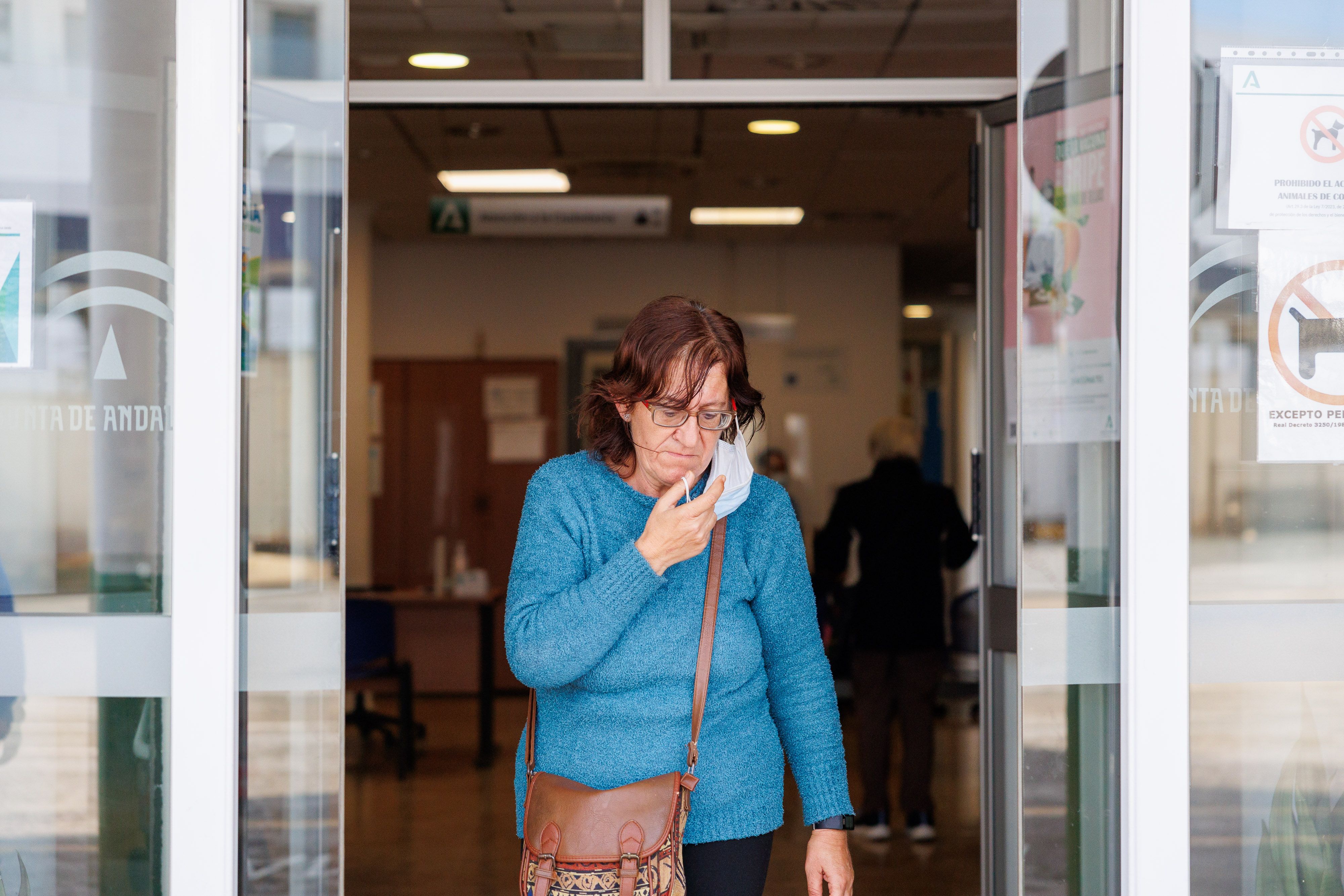 Una mujer sale de un centro de salud de Andalucía con mascarilla.