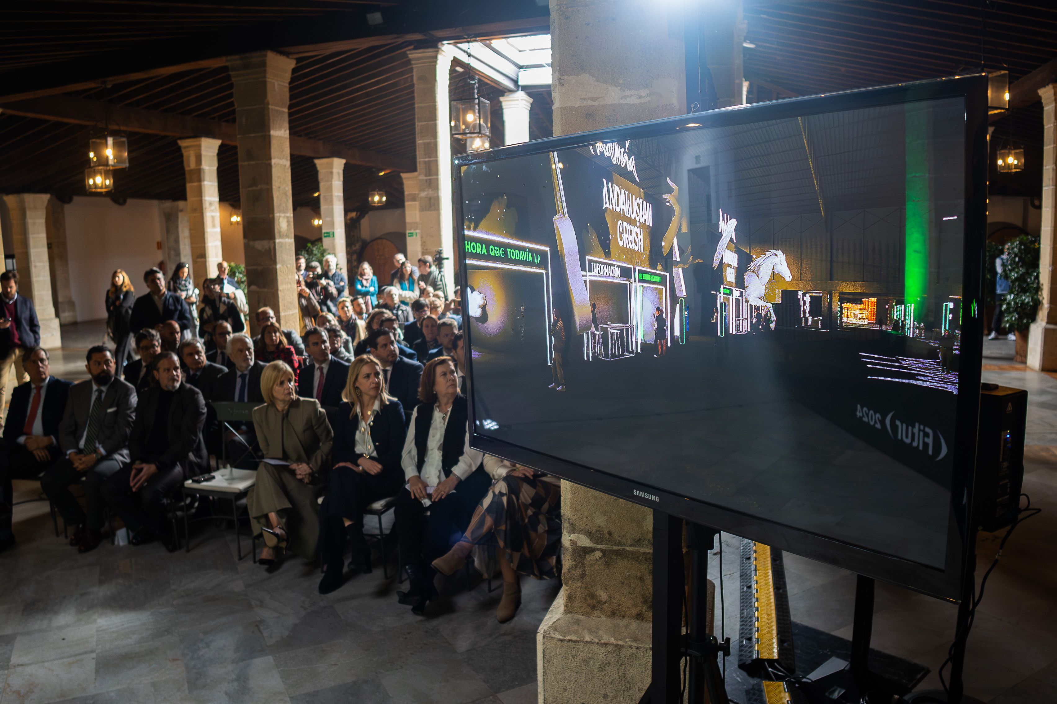 Representantes políticos y empresariales visionan el vídeo de la presentación del stand de Andalucía en Fitur. 