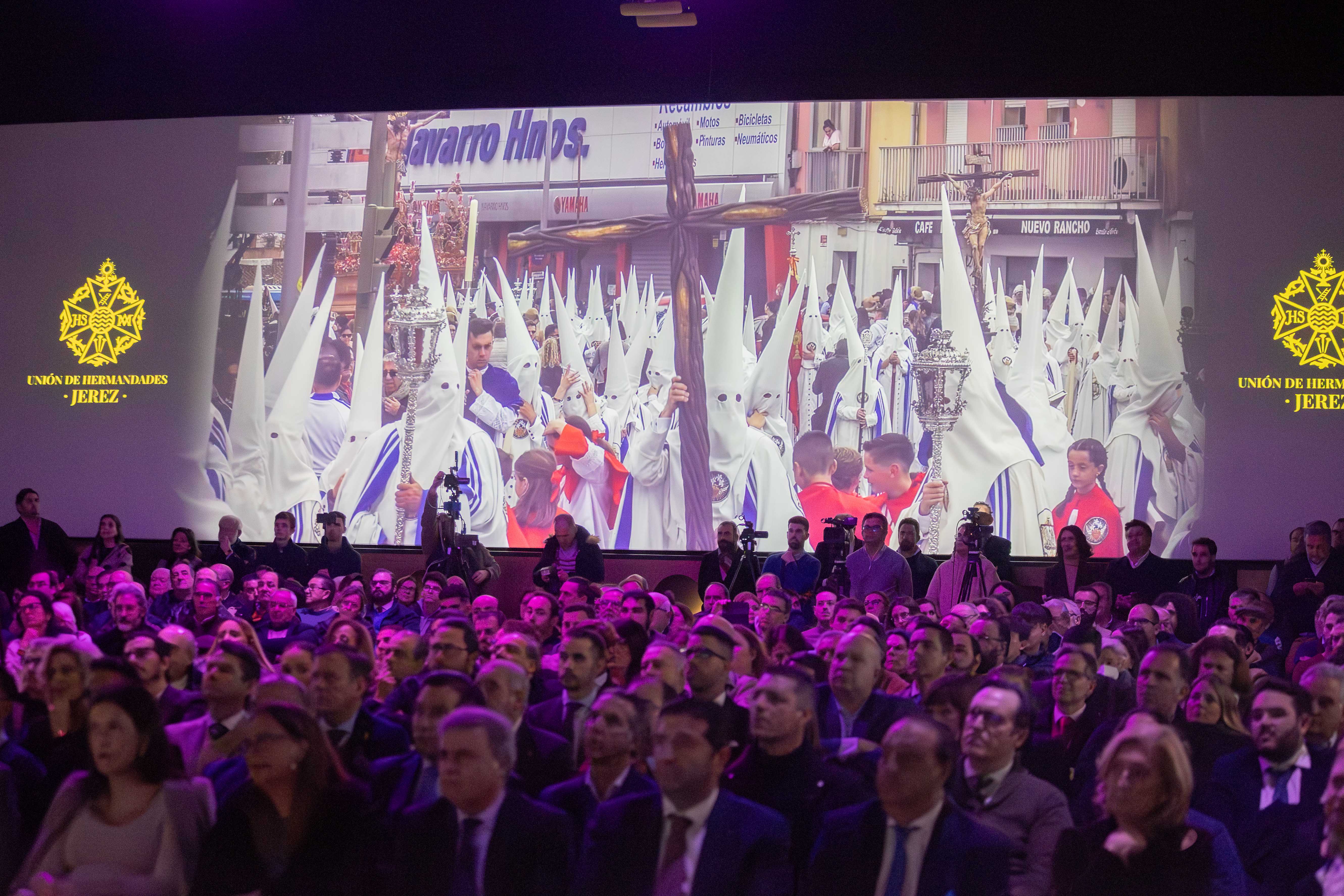 La sala repleta de público mientras se proyecta un vídeo.