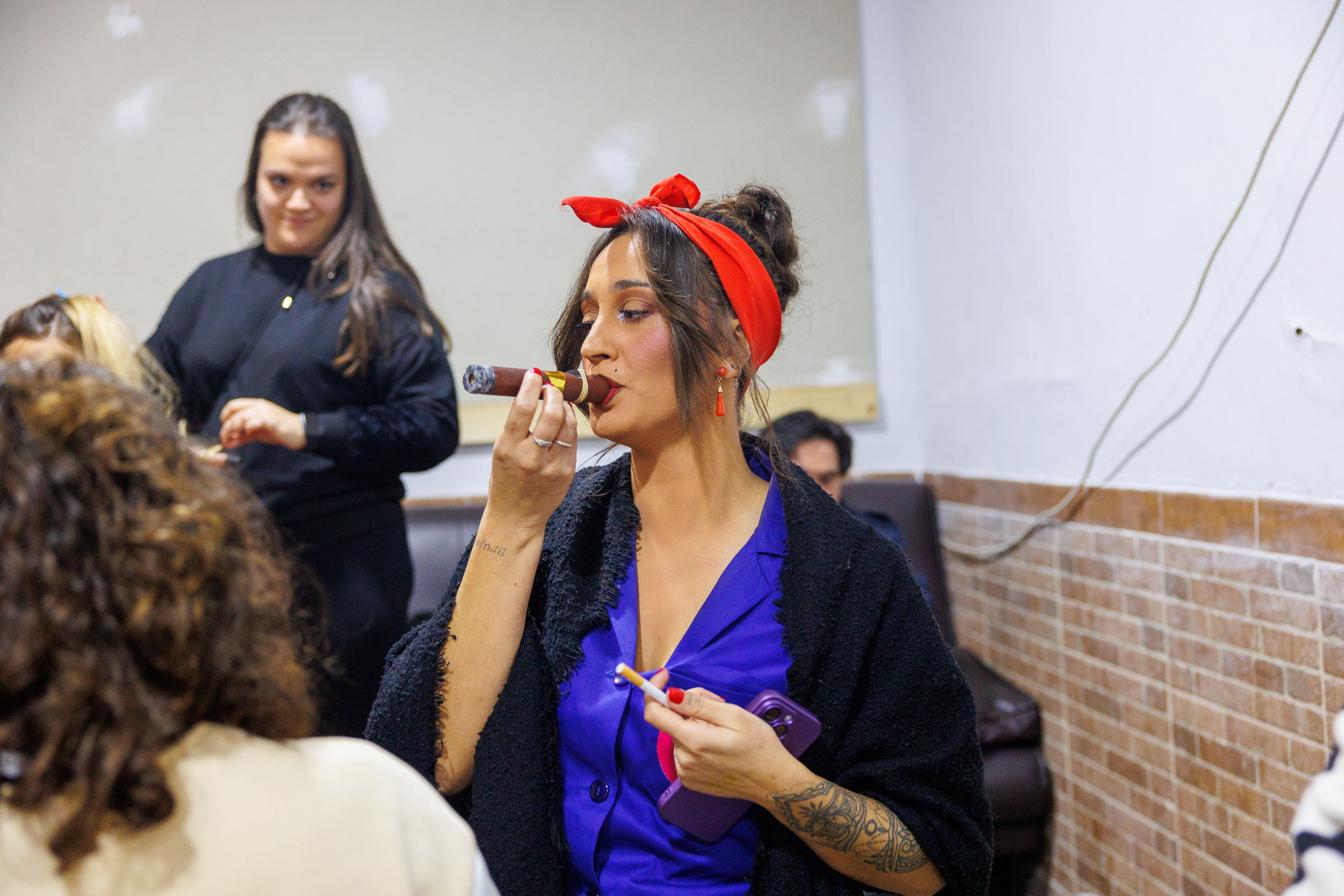 Una comparsista prueba el puro que forma parte esencial del tipo.