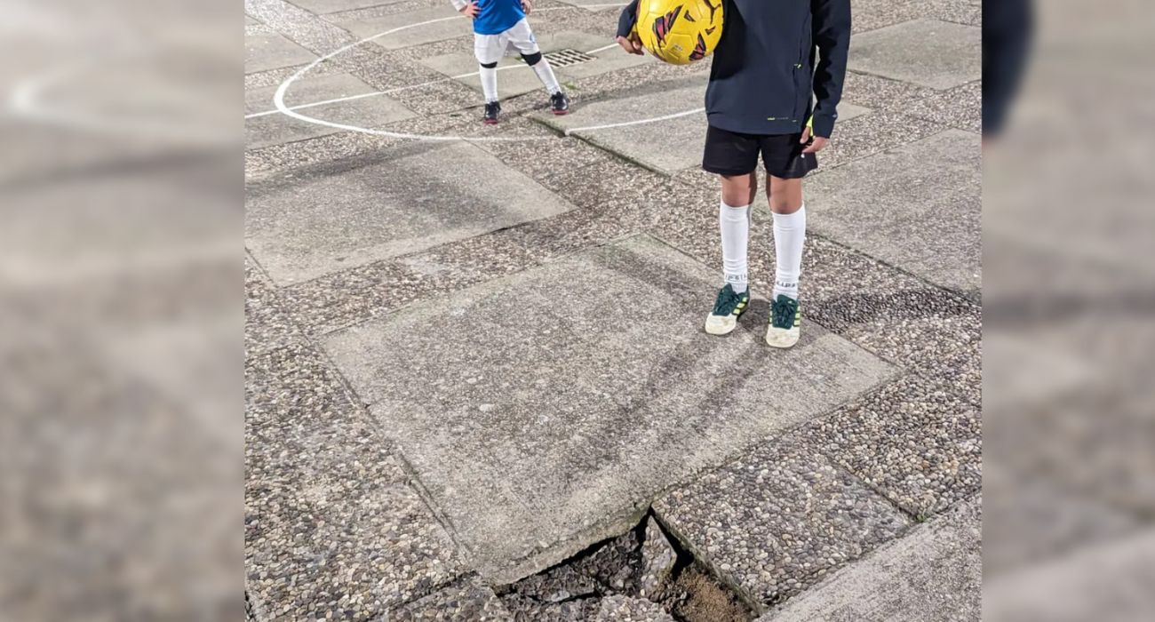 Dos niños, ante el socavón que impide jugar al balón en una plazoleta de La Granja.