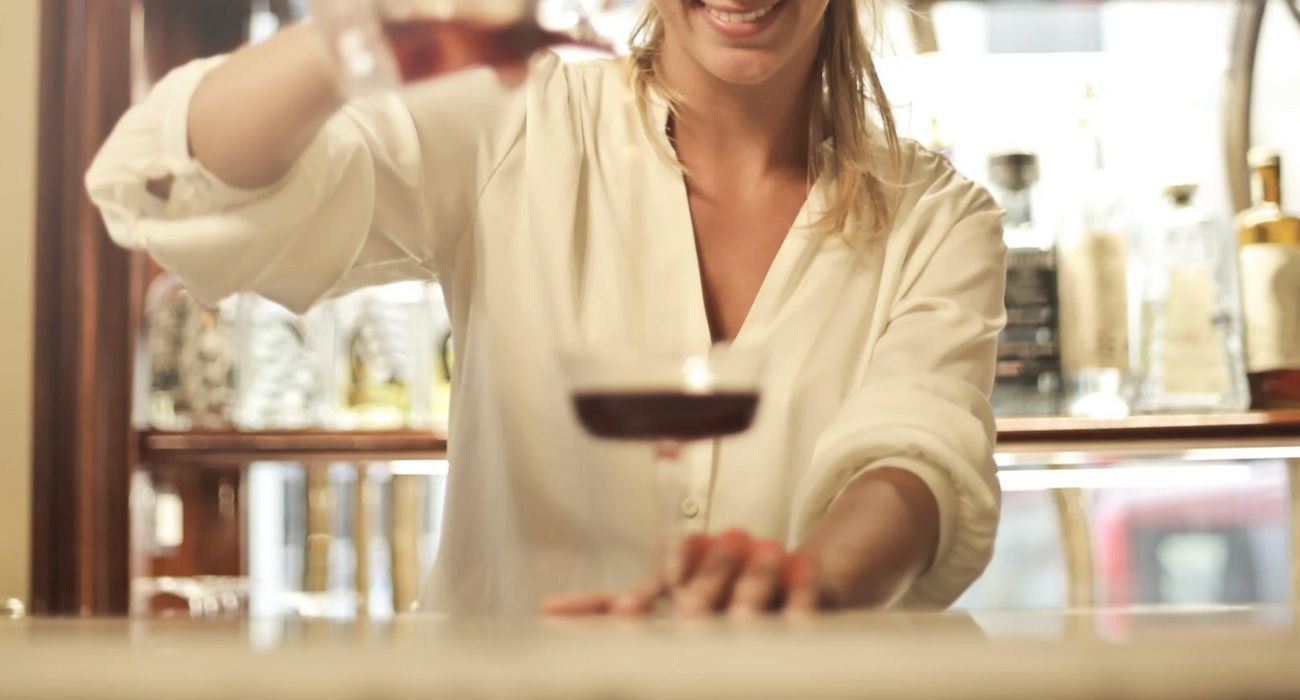 Una camarera, sirviendo una copa en un bar.