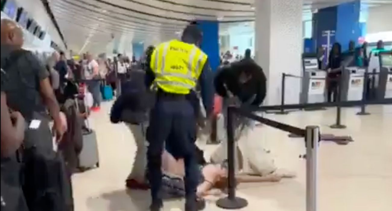 La mujer, tirada en el suelo del aeropuerto.