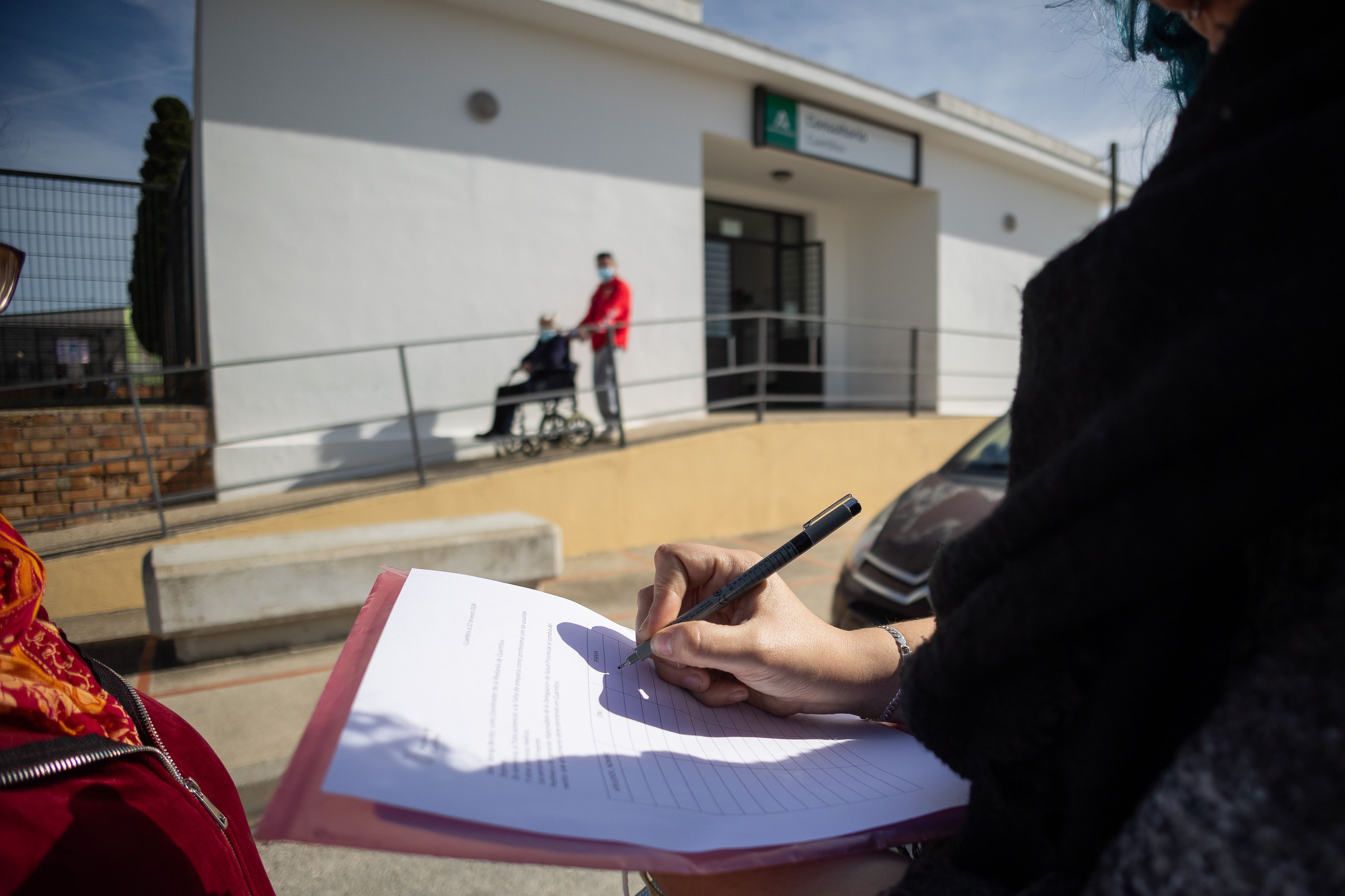 Una vecina firma la hoja con la que Cuartillos reclama un cambio de médico.