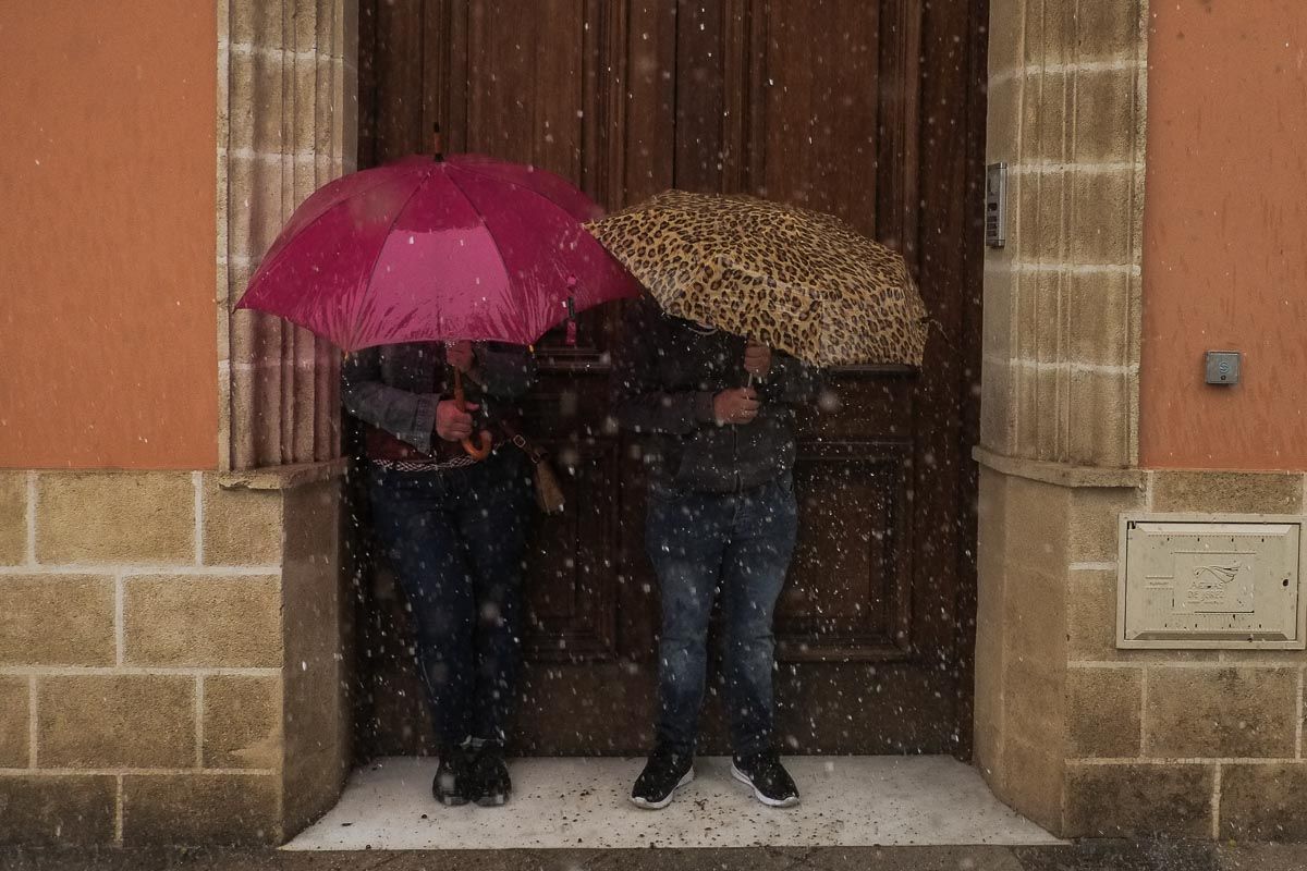 Dos personas se refugian de las fuertes lluvias, en una imagen de archivo.
