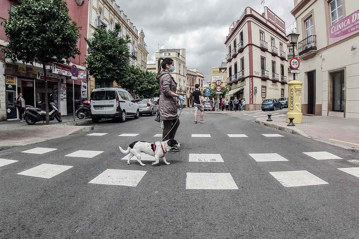 Una mujer cruza una calle en Sevilla, en una imagen de archivo.