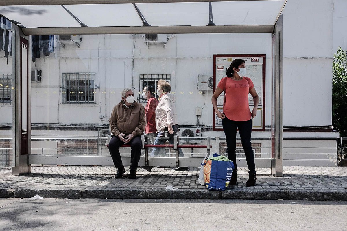 Dos personas esperan al autobús en Sevilla en una fotografía de archivo. Robos y estafas en los autobuses de Sevilla: así operaban una 'pareja' itinerante de ladrones.