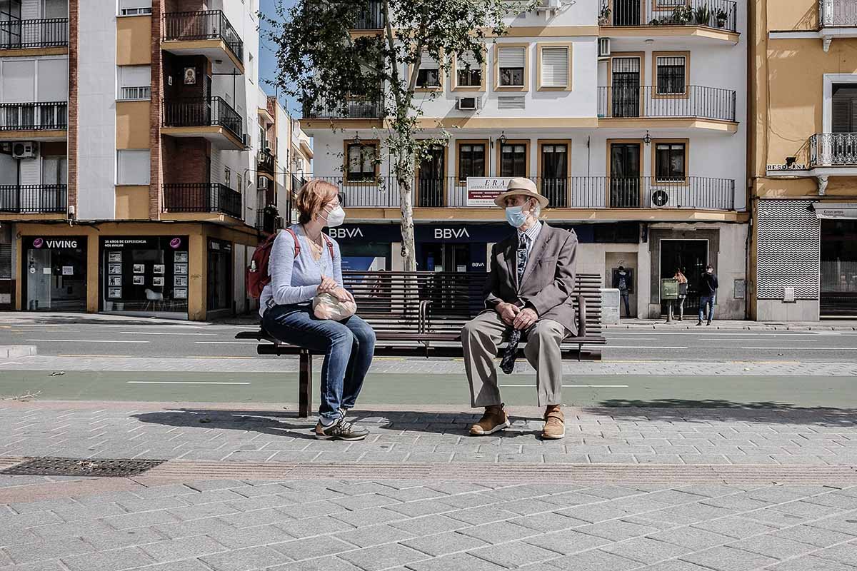 Dos personas en un banco en Sevilla, en días pasados. FOTO: JOSÉ LUIS TIRADO (www.joseluistirado.es)
