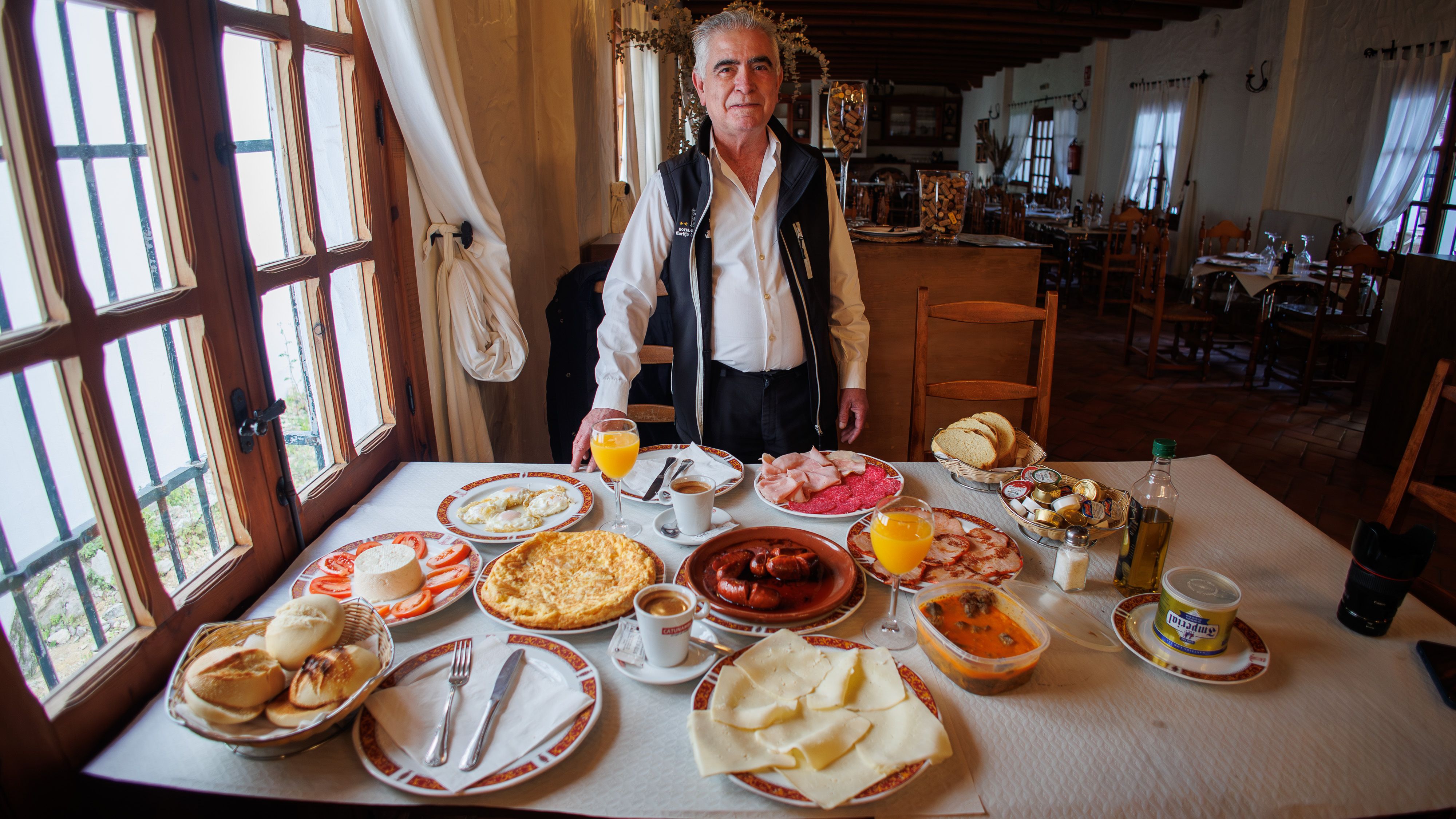 Juan Román, propietario del Hotel Cortijo Las Grullas de Benalup, posando con el desayuno "completo".