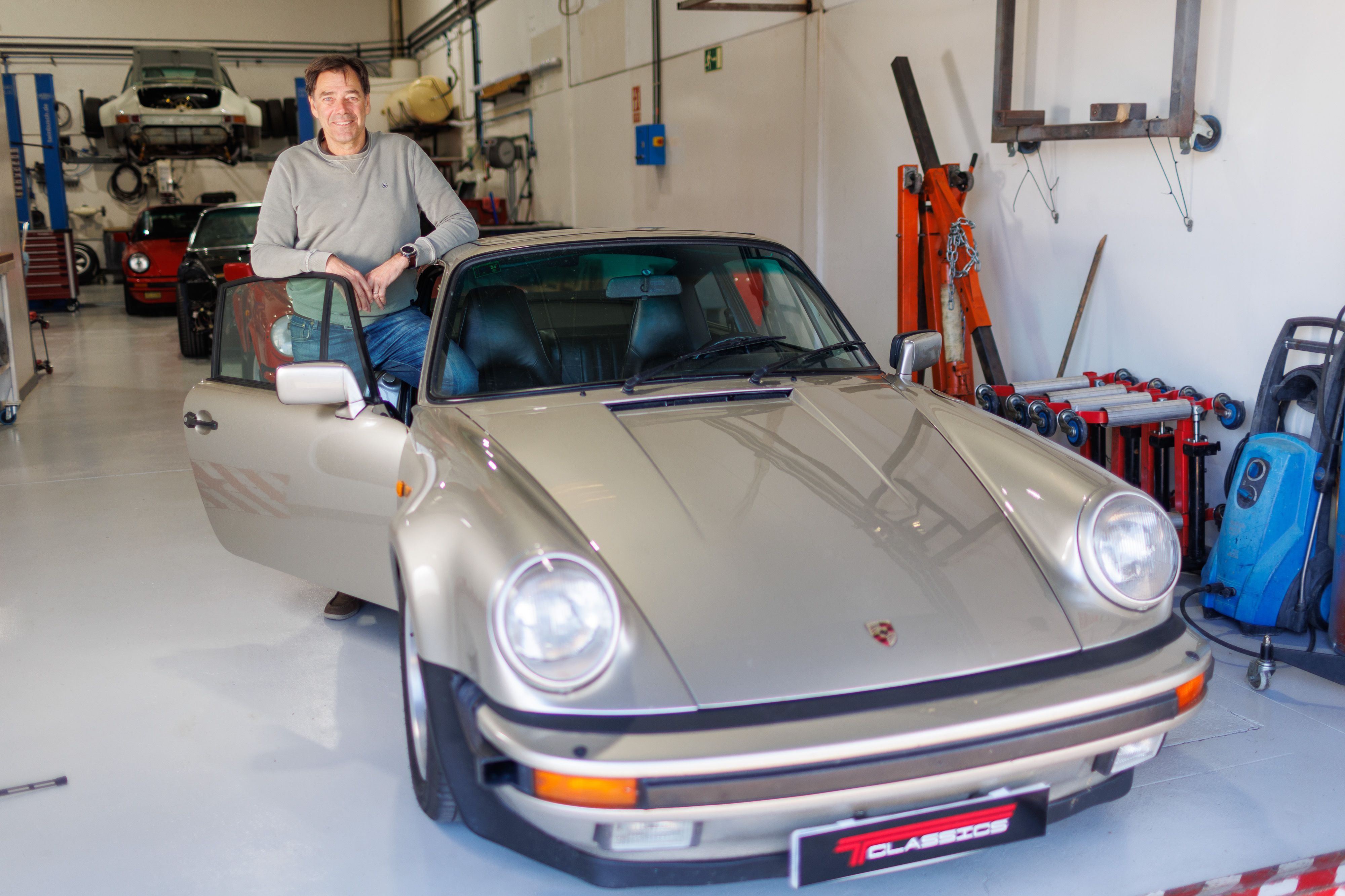 Michel junto a su Porsche Turbo look del 83 de color grisáceo.
