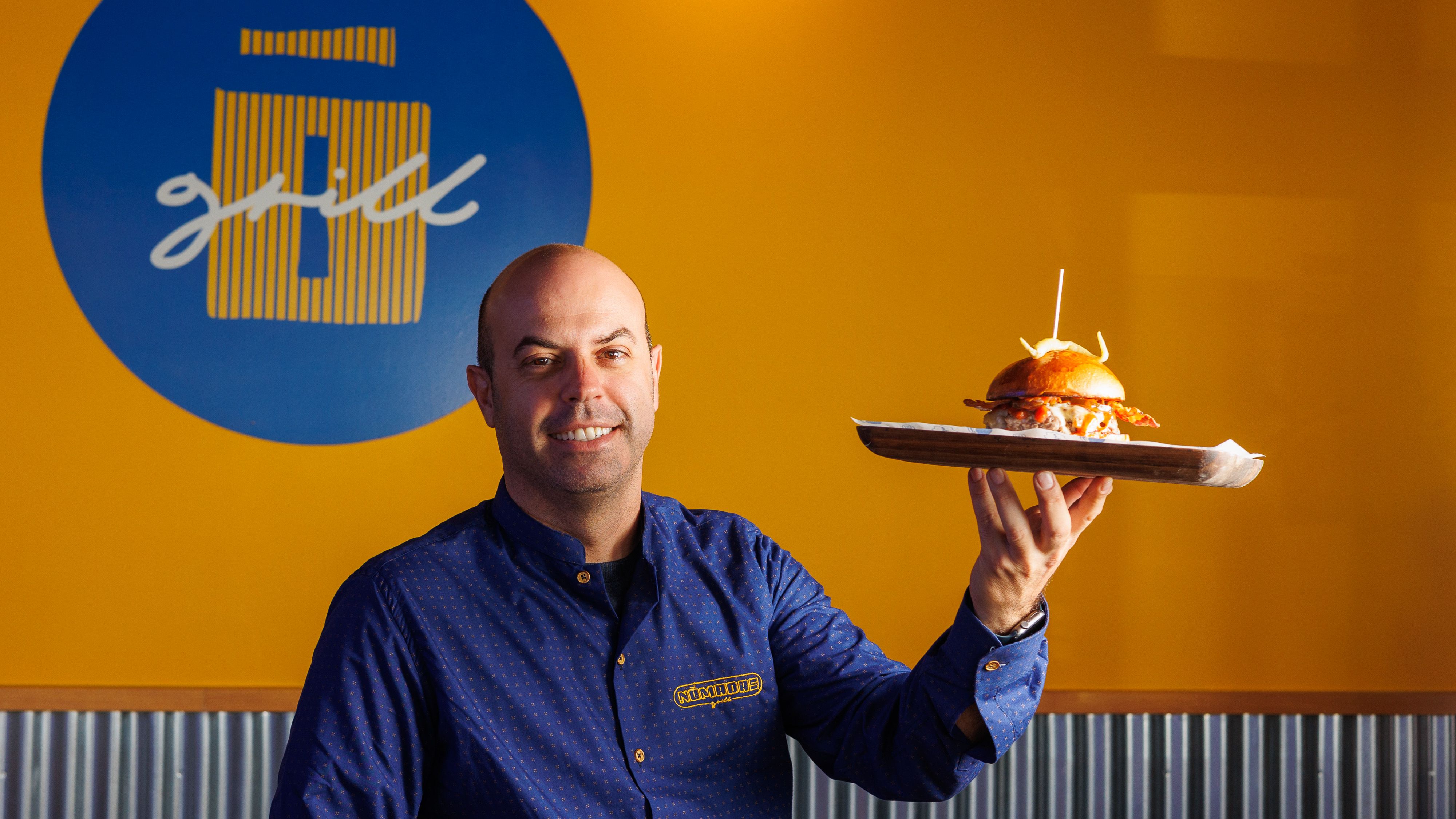 Manuel Moreno, dueño de Nomadas Grill en Chiclana, posa con la hamburguesa que aspira a ser la mejor de España este 2024.