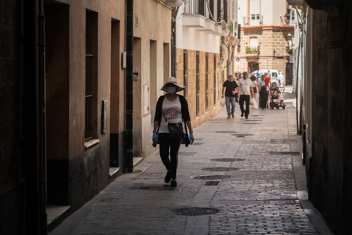 Una mujer con mascarilla camina por una céntrica calle de Cádiz, en días pasados. FOTO: MANU GARCÍA