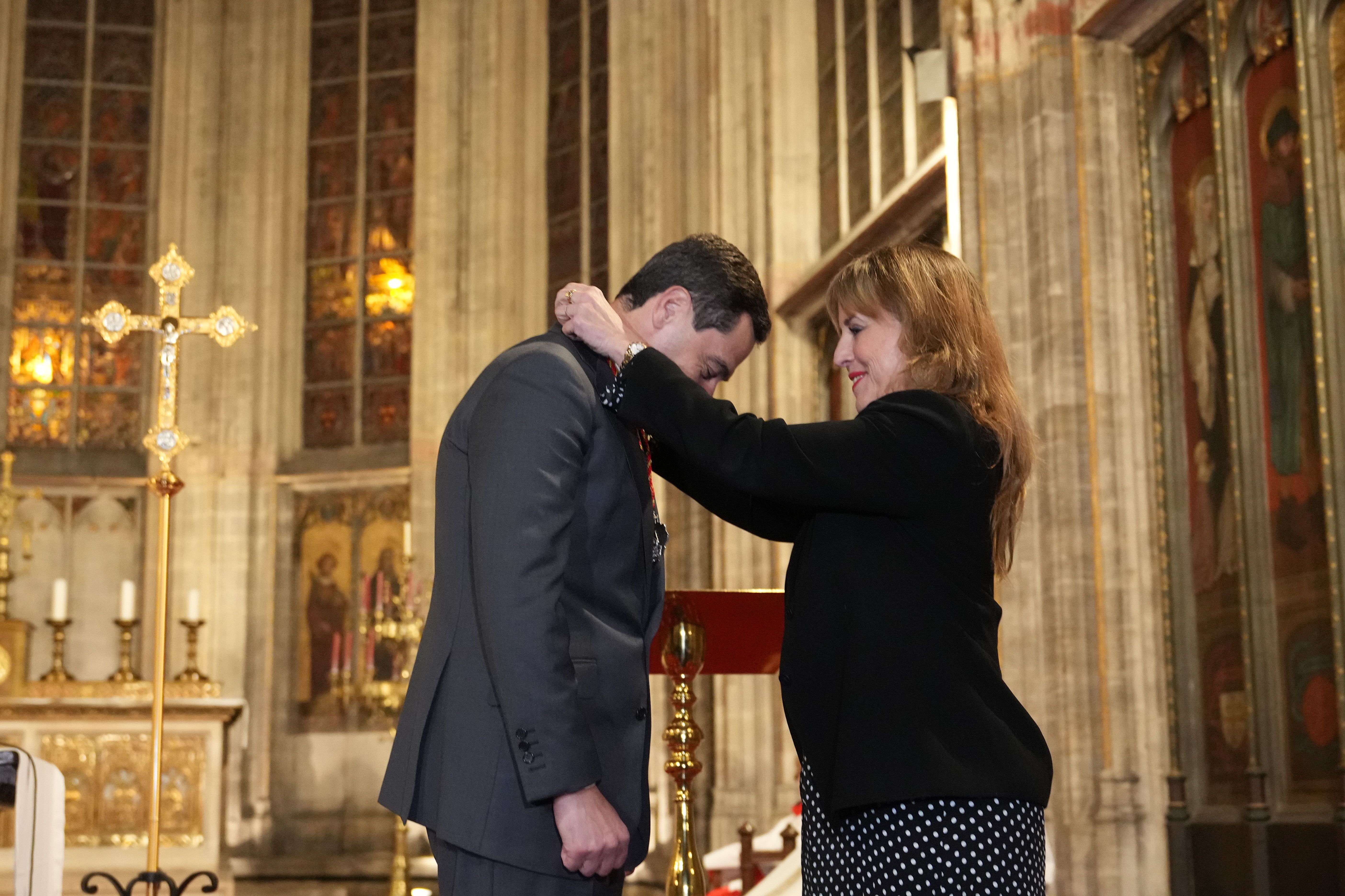 Juanma Moreno recibiendo la medalla de la Hermandad del Rocío de Bruselas.