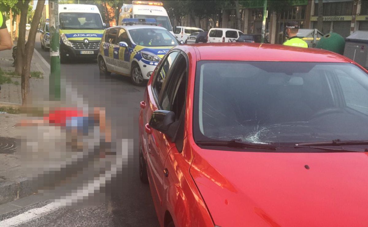 El hombre, tendido en la acera junto al coche. FOTO: Emergencias Sevilla