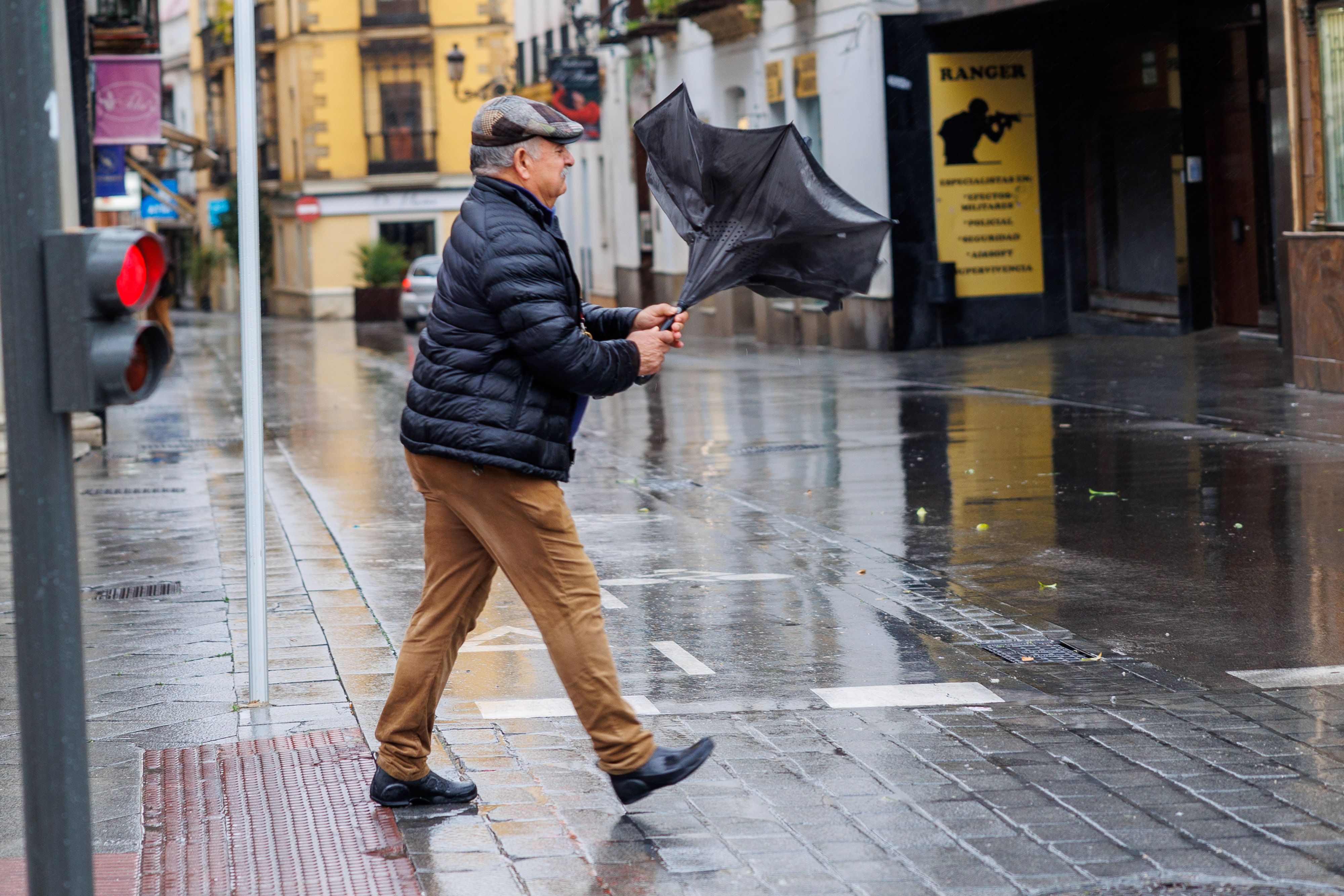 Llueve. A un hombre se le da la vuelta el paraguas en Jerez durante el último temporal.
