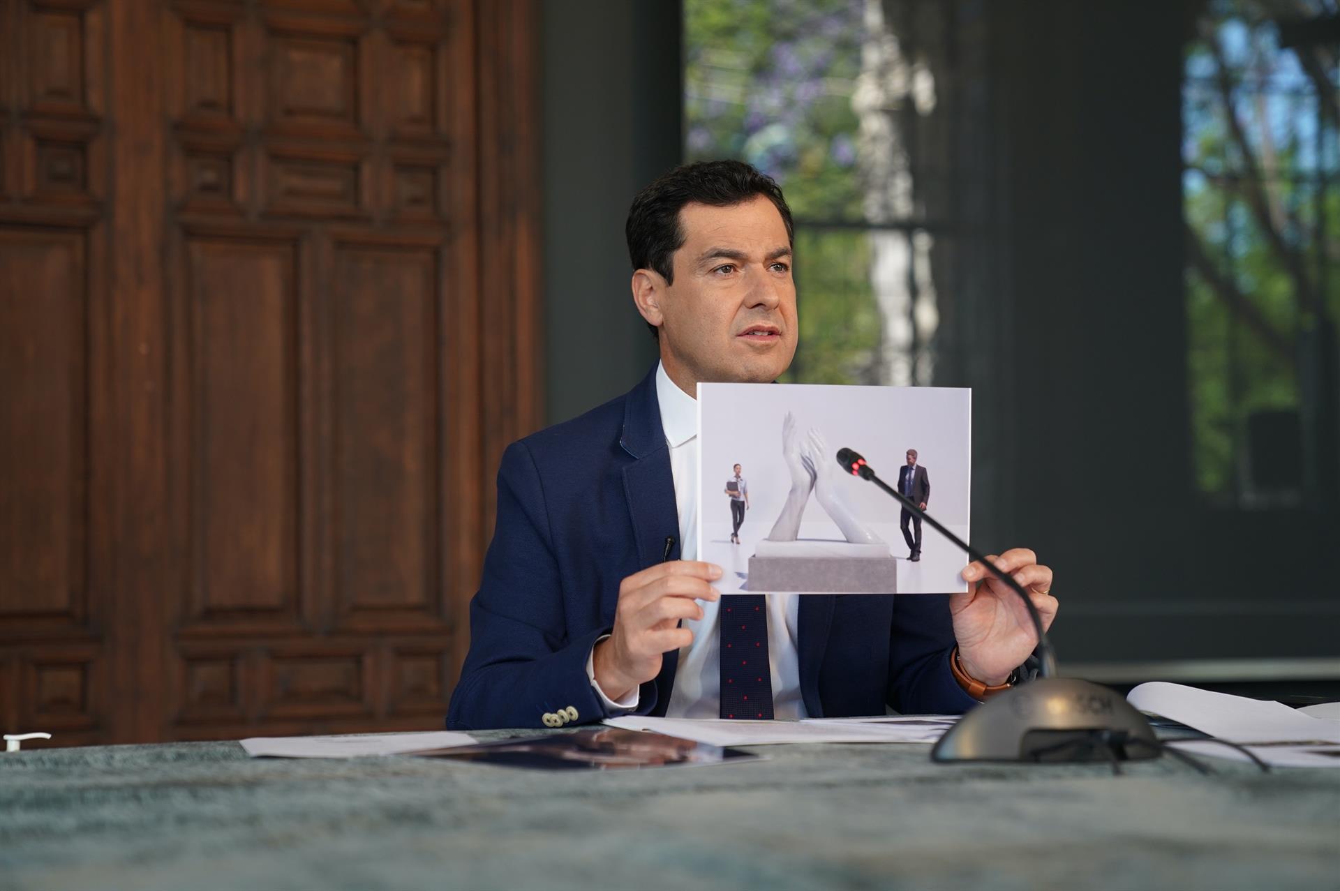 Moreno, mostrando un boceto con la escultura.