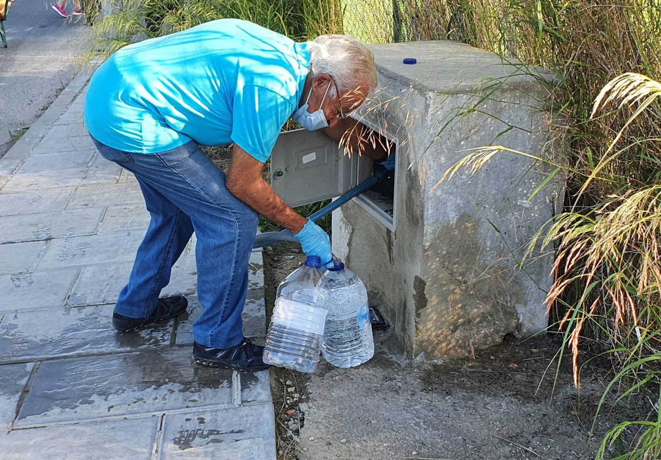 Un vecino de Almensilla, rellenando una garrafa.