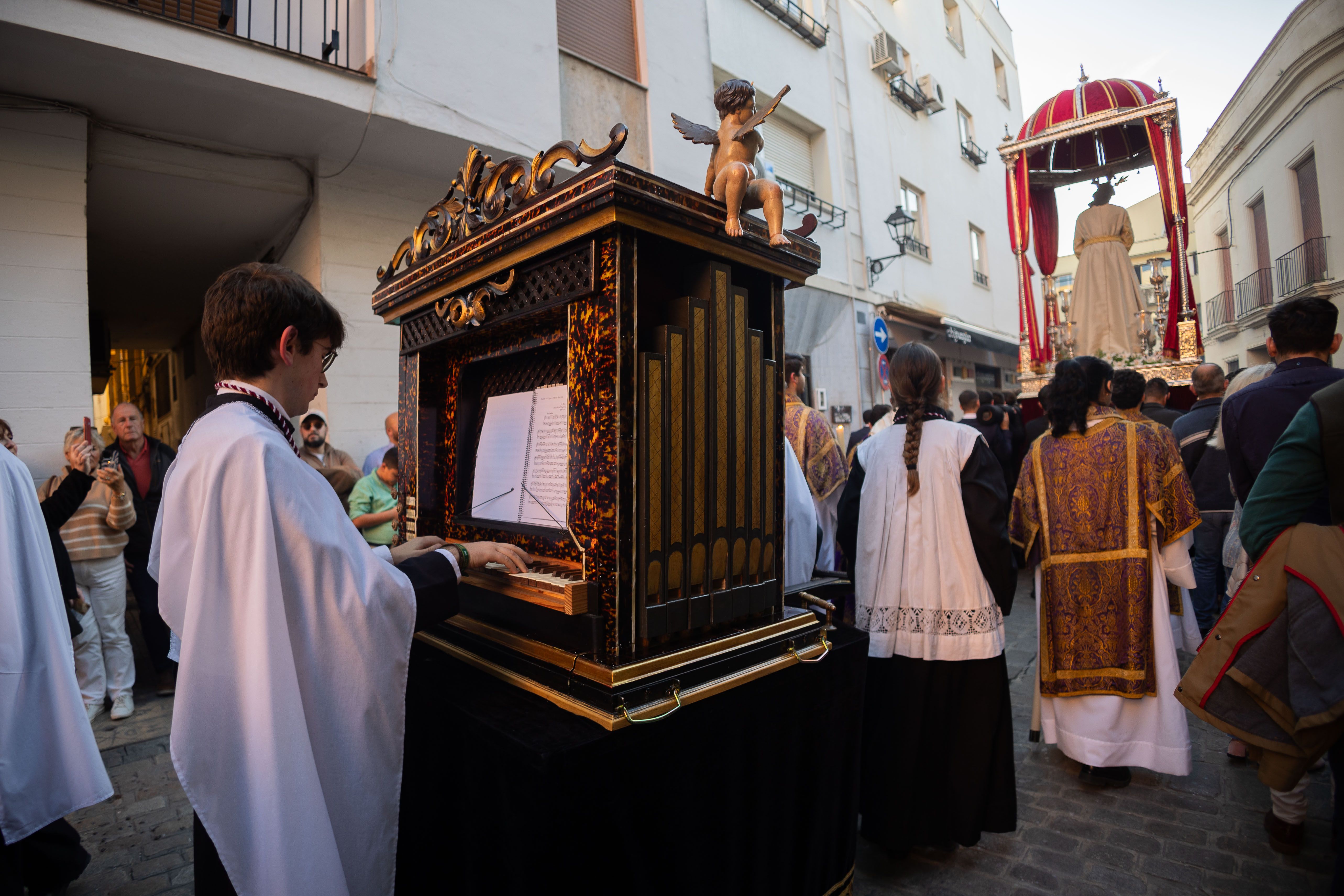 El grupo coral y el realejo tras las andas del Señor del Consuelo. 