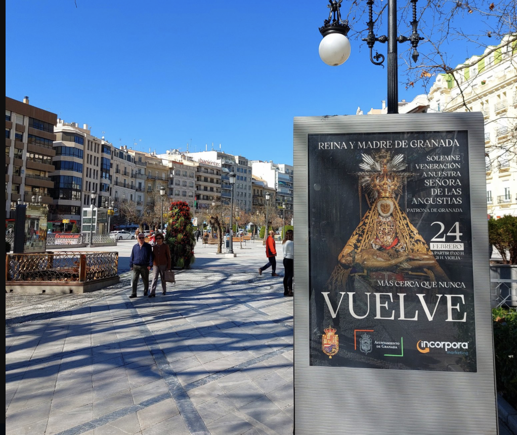 Uno de los Mupis publicitarios con el cartel de la vuelta de la imagen, en el centro de Granada.