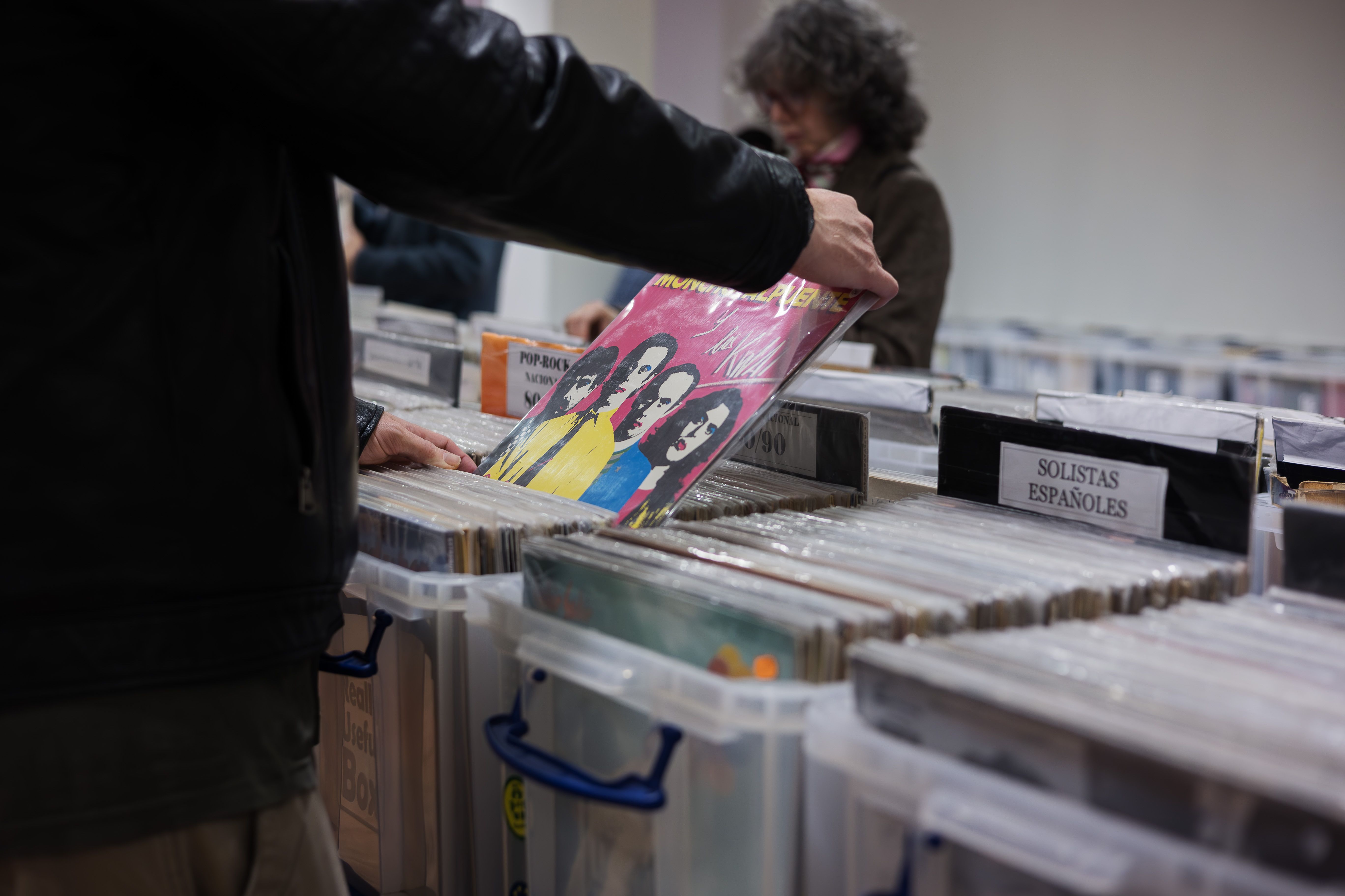 Detalle de una persona ojeando un disco.