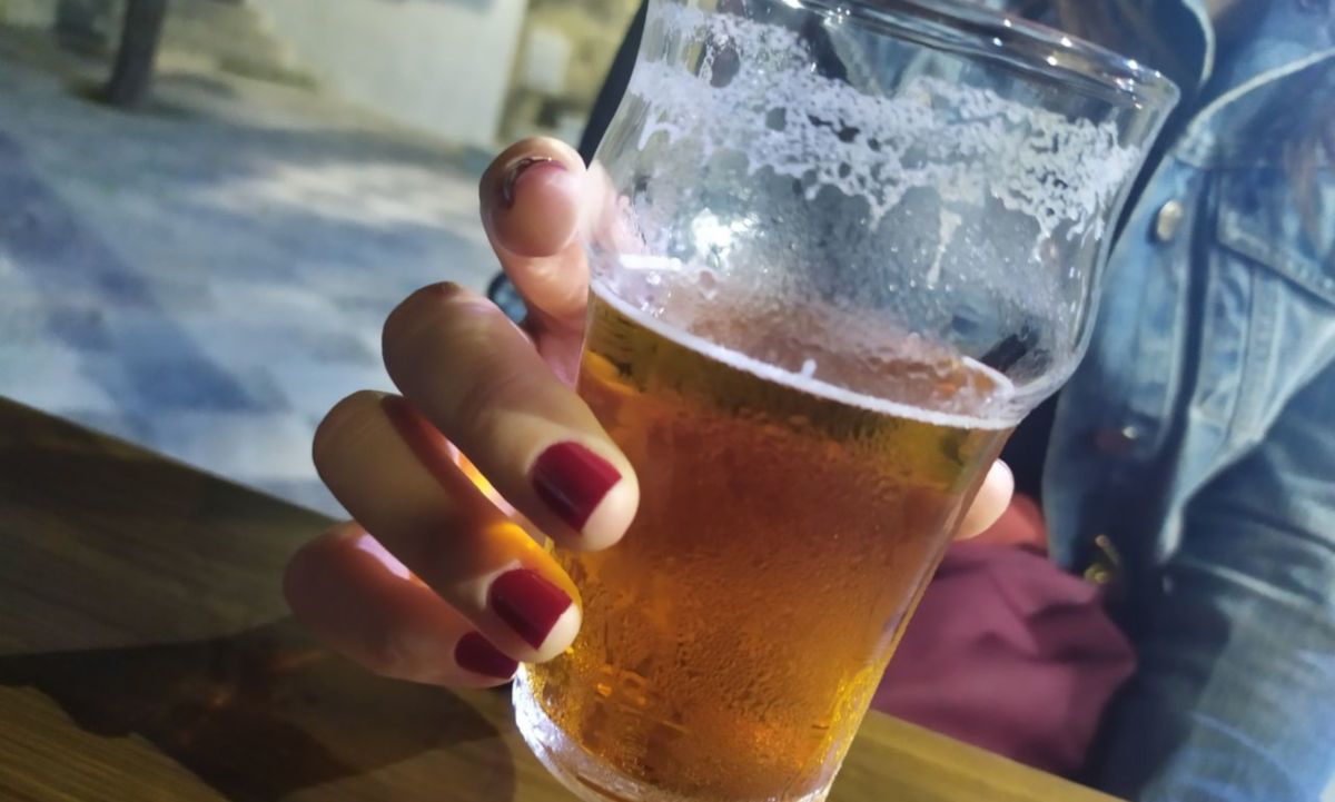 Una mujer se toma una cerveza en un pub en una imagen de archivo.