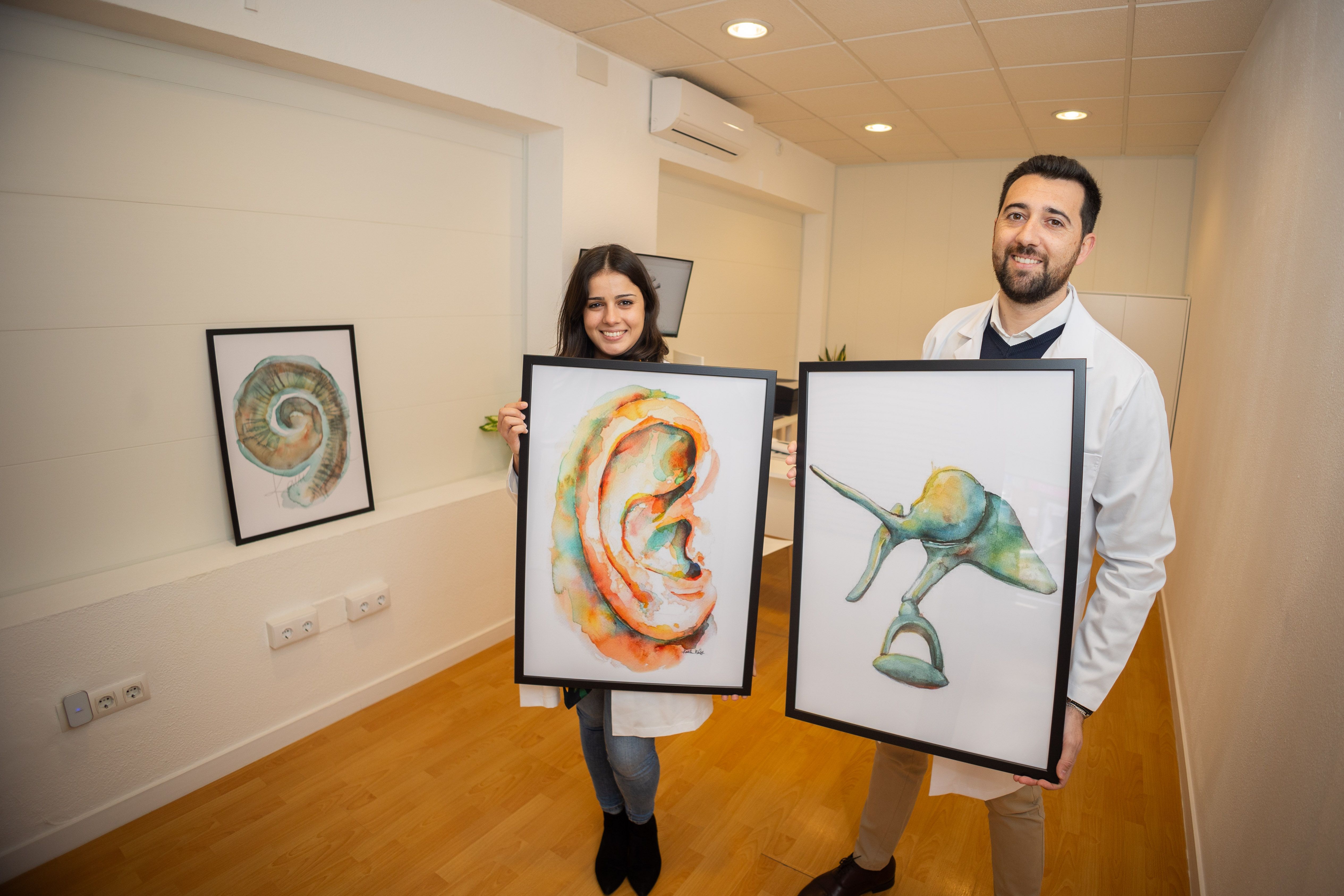 Los dos especialistas en audición con laminas alusivas al oído.