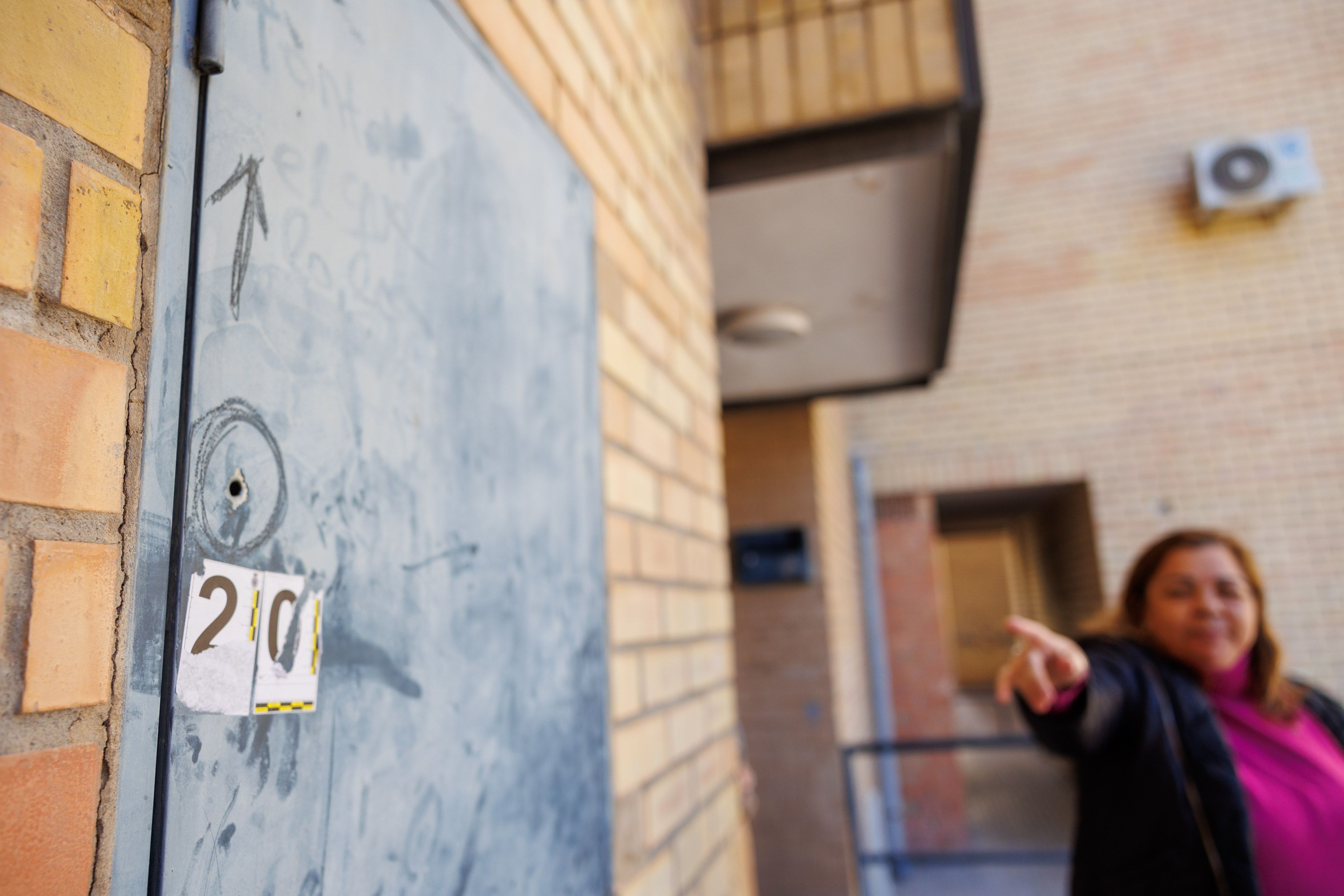 Una vecina del 'Mopu' señala un impacto de bala en un bloque tras el último tiroteo por ajustes de cuentas del narco, en una imagen de esta semana.