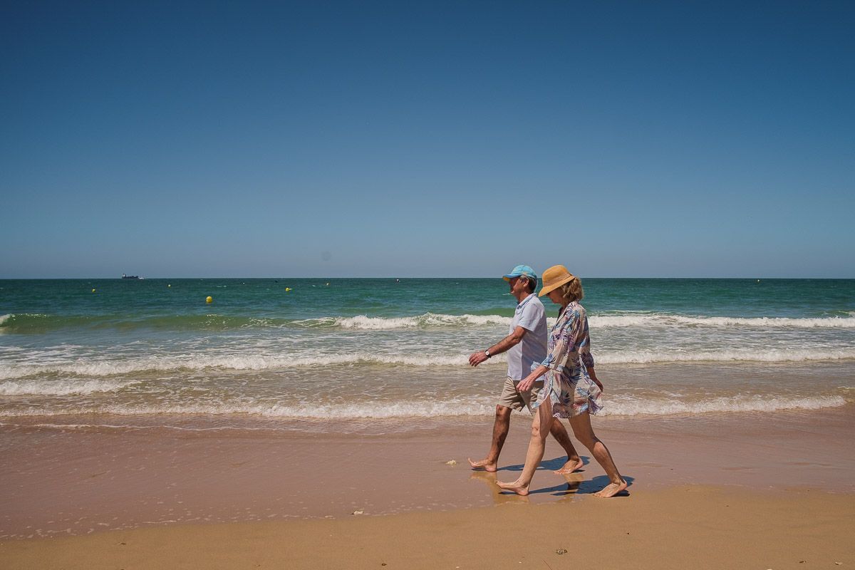 Personas paseando por una playa de El Puerto, en el final de la temporada.