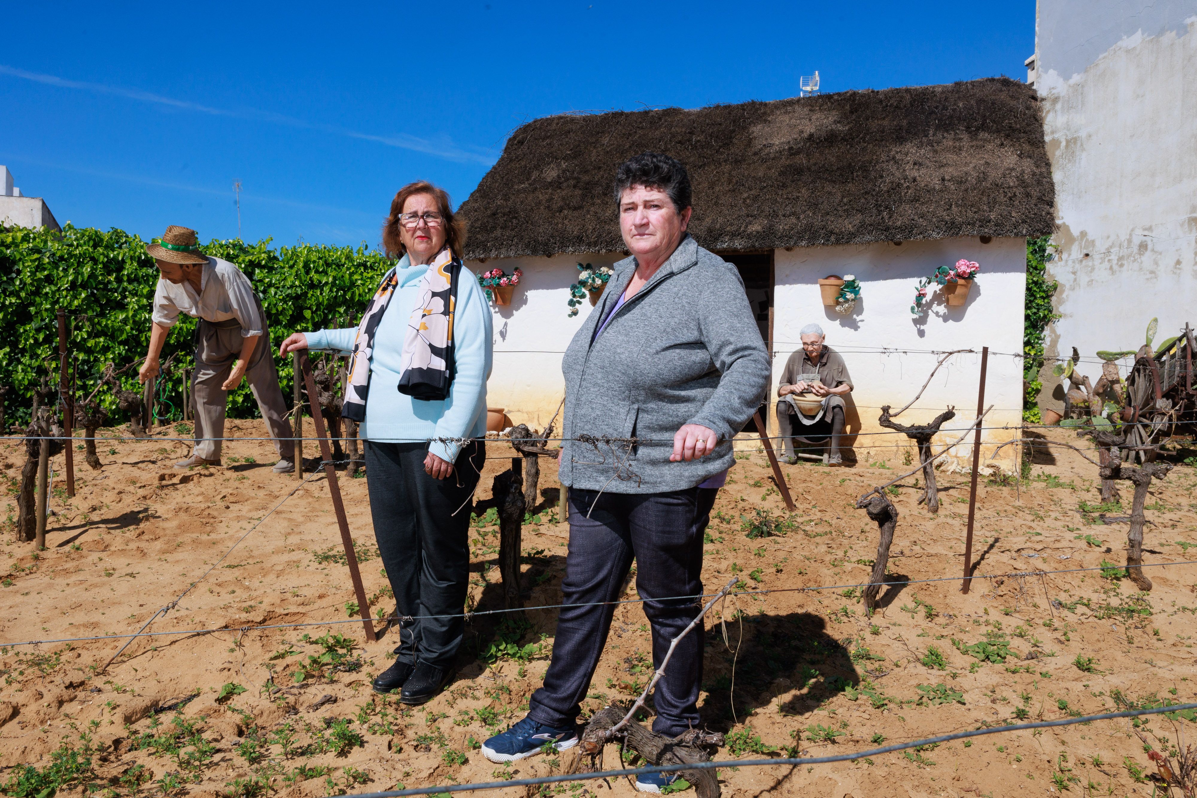 Concepción Cruces y Caridad Miranda en una parte del Museo del Moscatel, de la Cooperativa Católico Agrícola de Chipiona, donde se ejemplifica la visión tradicional del hombre en el campo y la mujer en la casa.