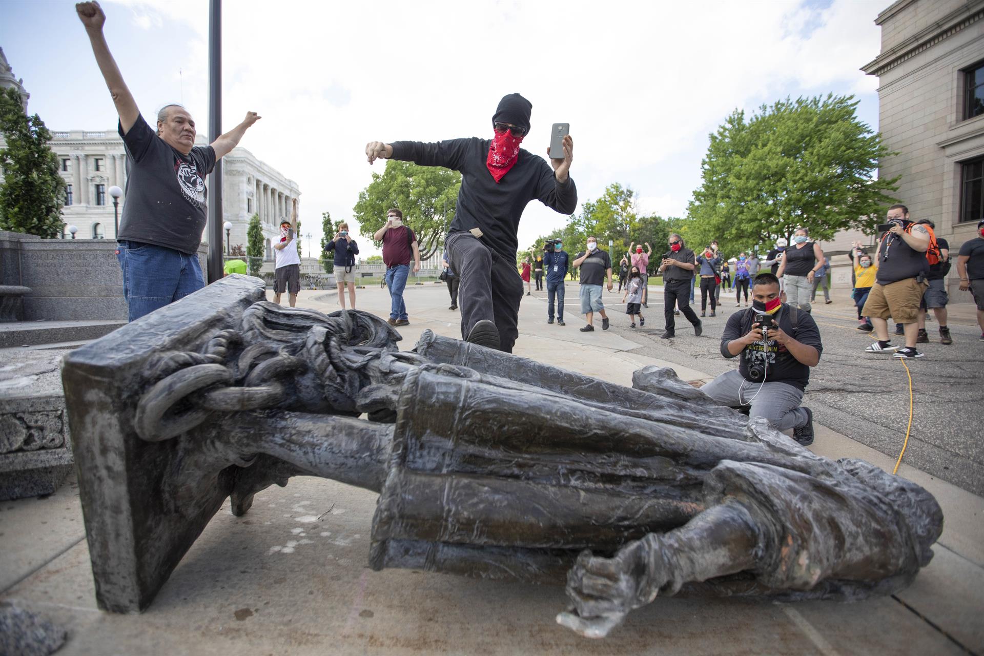 Unos hombres ante una estatua de Colón derribada. FOTO: Chris Juhn/ZUMA Wire/dpa