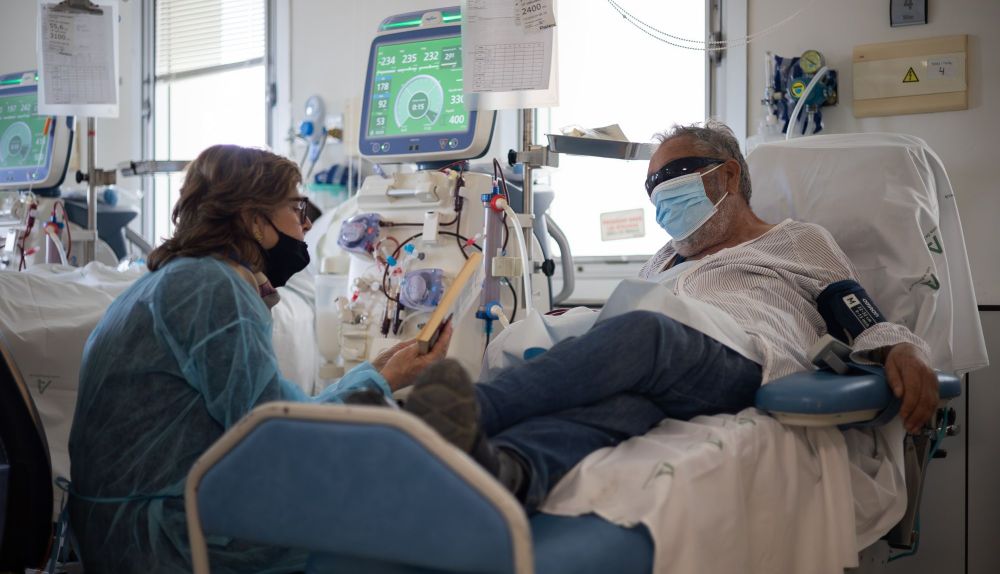 Begoña lee a Paco durante su sesión de diálisis.