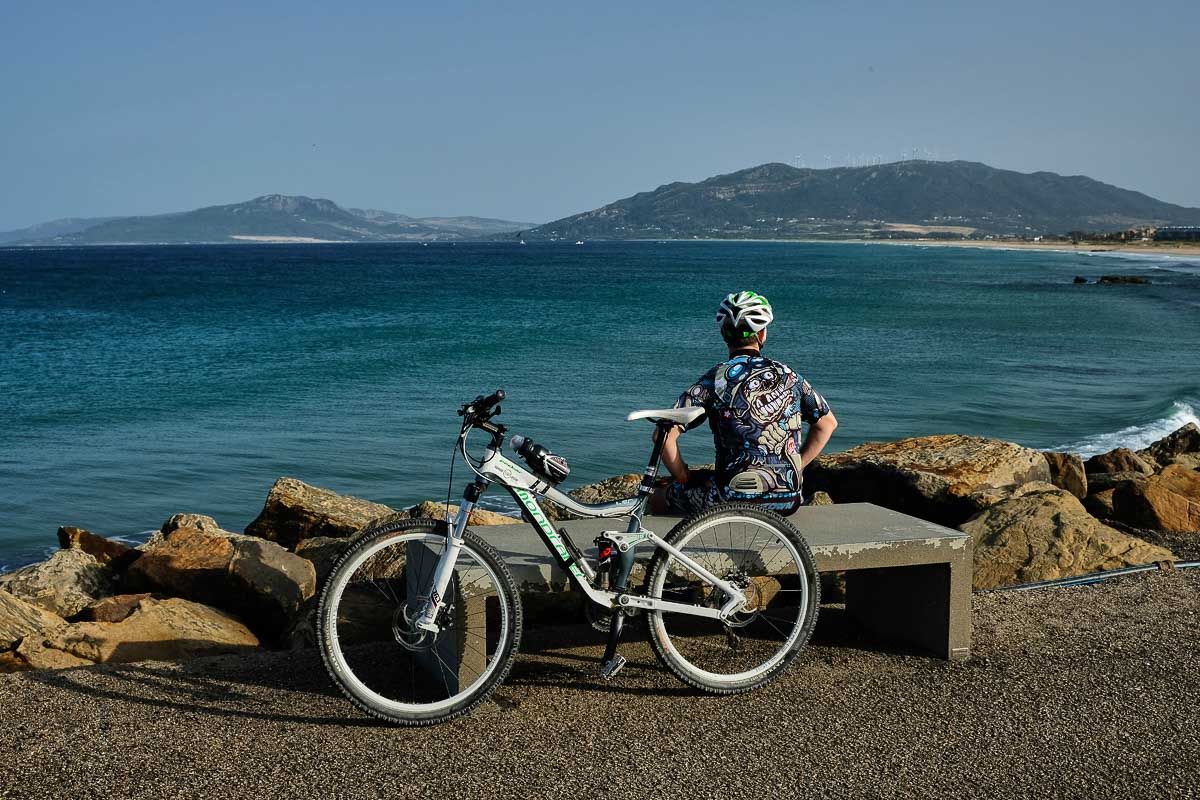 Un ciclista, descansando cerca de Tarifa, una de las localidades de Andalucía en nivel 3 de alerta.