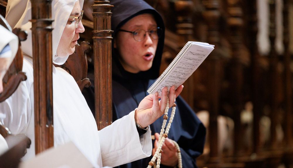 Dos monjas catando en el coro de los presbiterios de la Iglesia. 