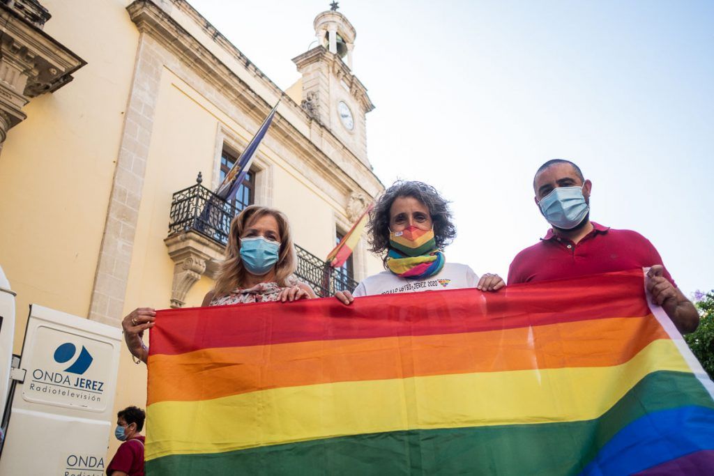 De izquierda a derecha, Toñi Asencio, Susana Domínguez y Salvador Mena, con la bandera arcoíris frente al Ayuntamiento de Jerez. FOTO: MANU GARCÍA