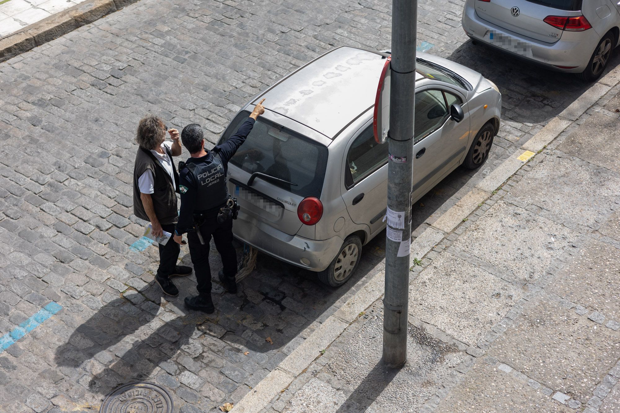 Un agente avisa a un conductor de que está mal estacionado en el centro de Jerez.