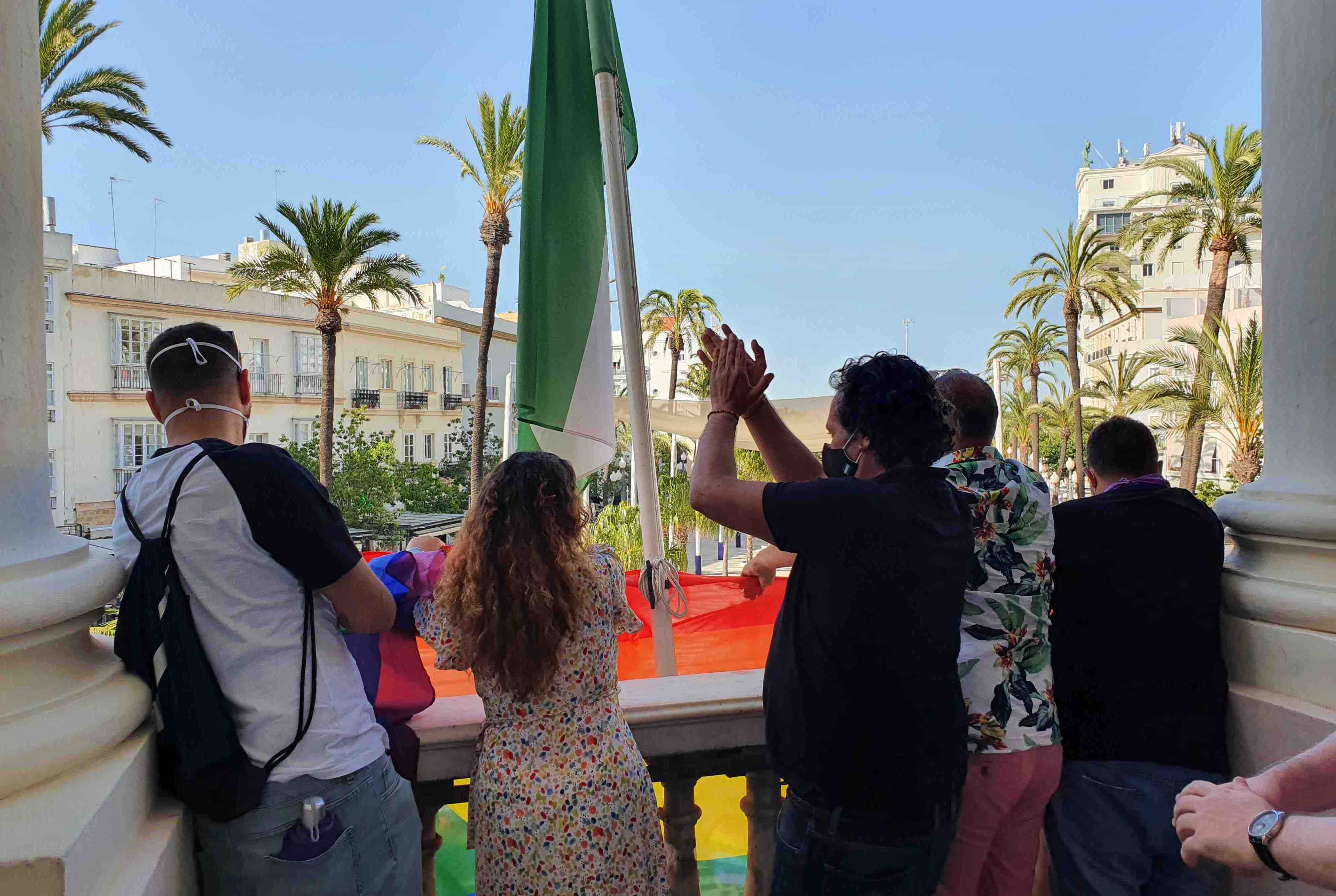 El alcalde de Cádiz, en primer término, aplaude, tras arriar la bandera LGTBI por orden judicial.