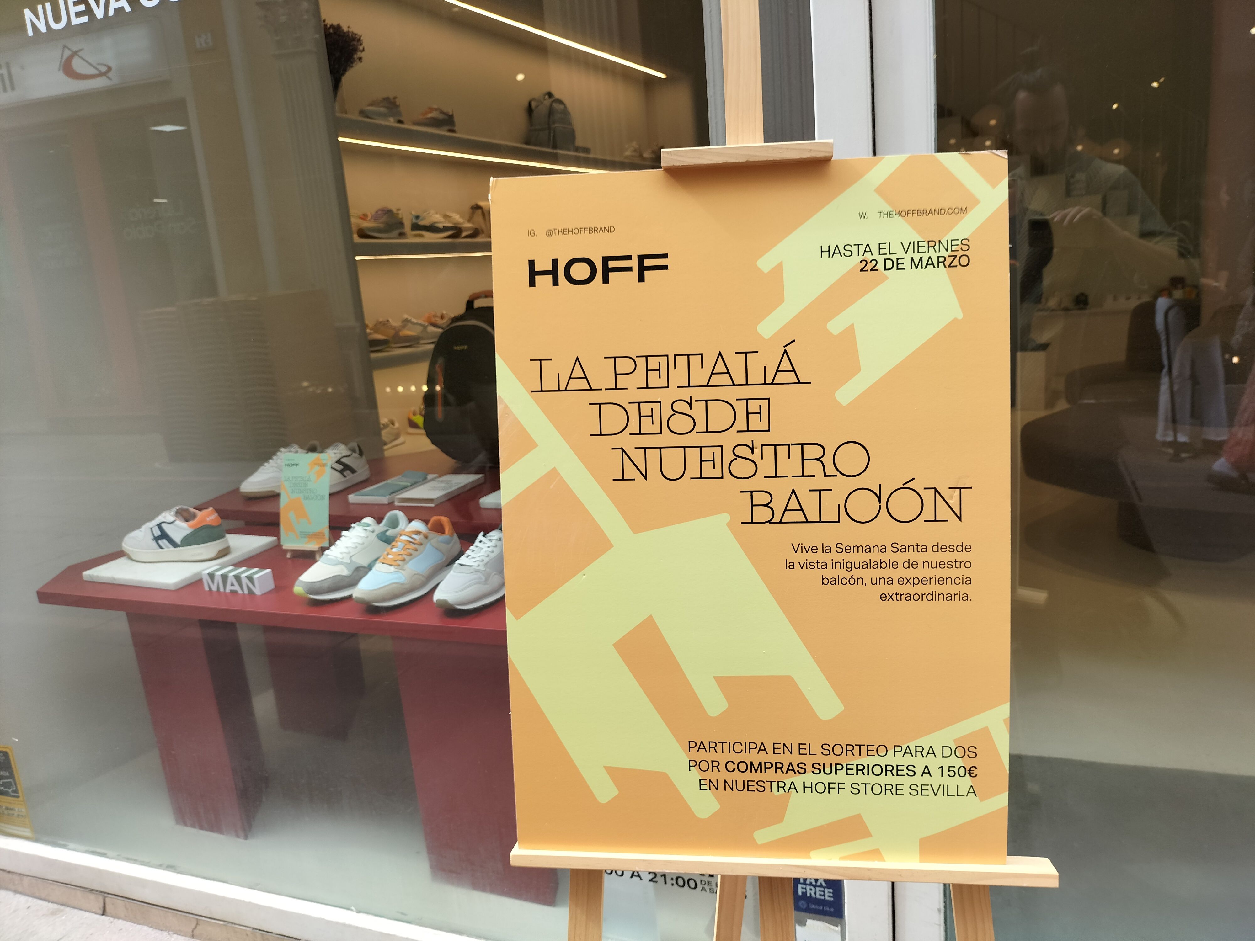 Un comercio de Sevilla sortea plazas en su balcón. Cartel que promociona el sorteo en la puerta del establecimiento.